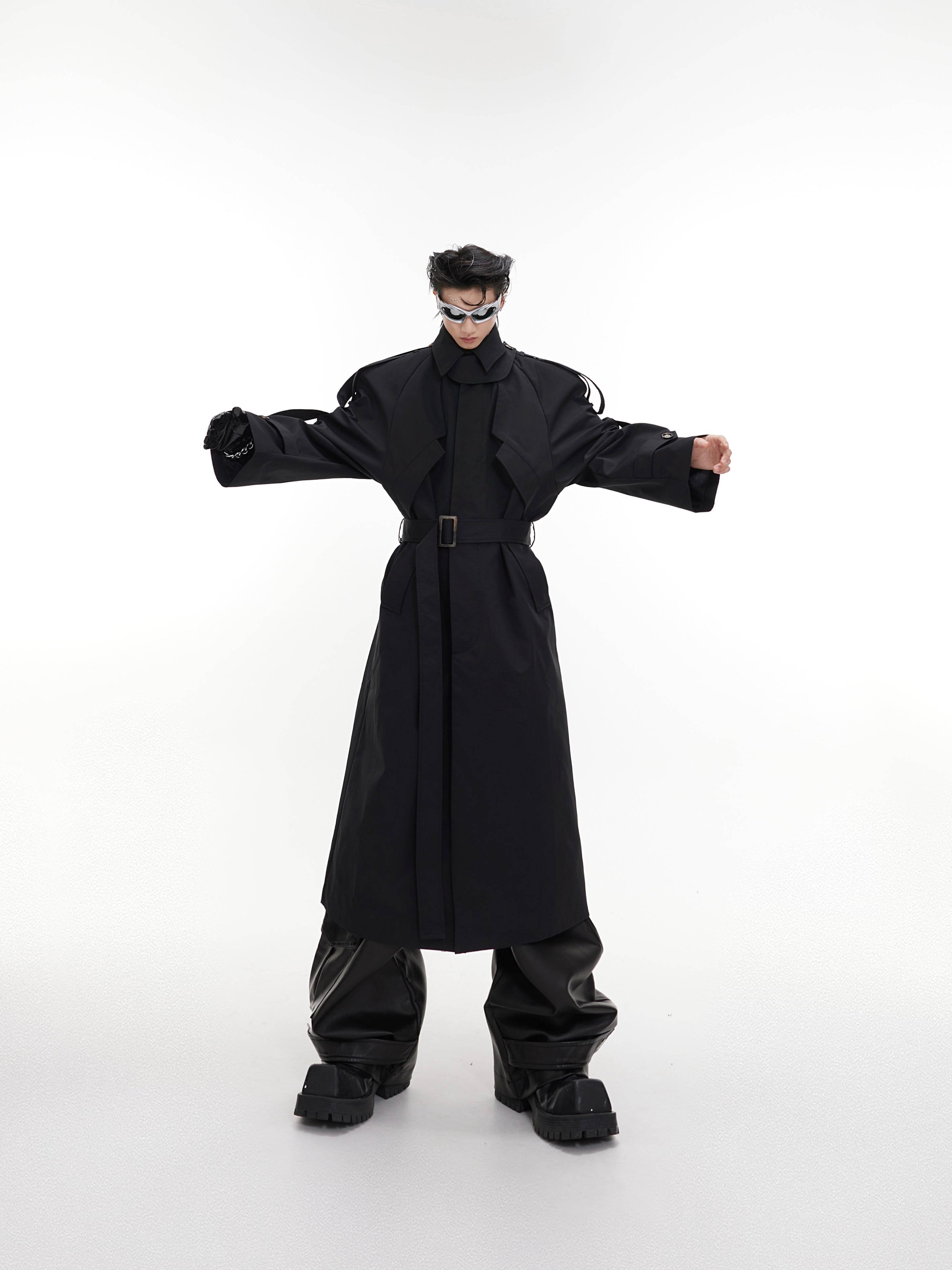 Detailed view of asymmetric hem on deconstructed longline trench coat, highlighting modern streetwear design elements