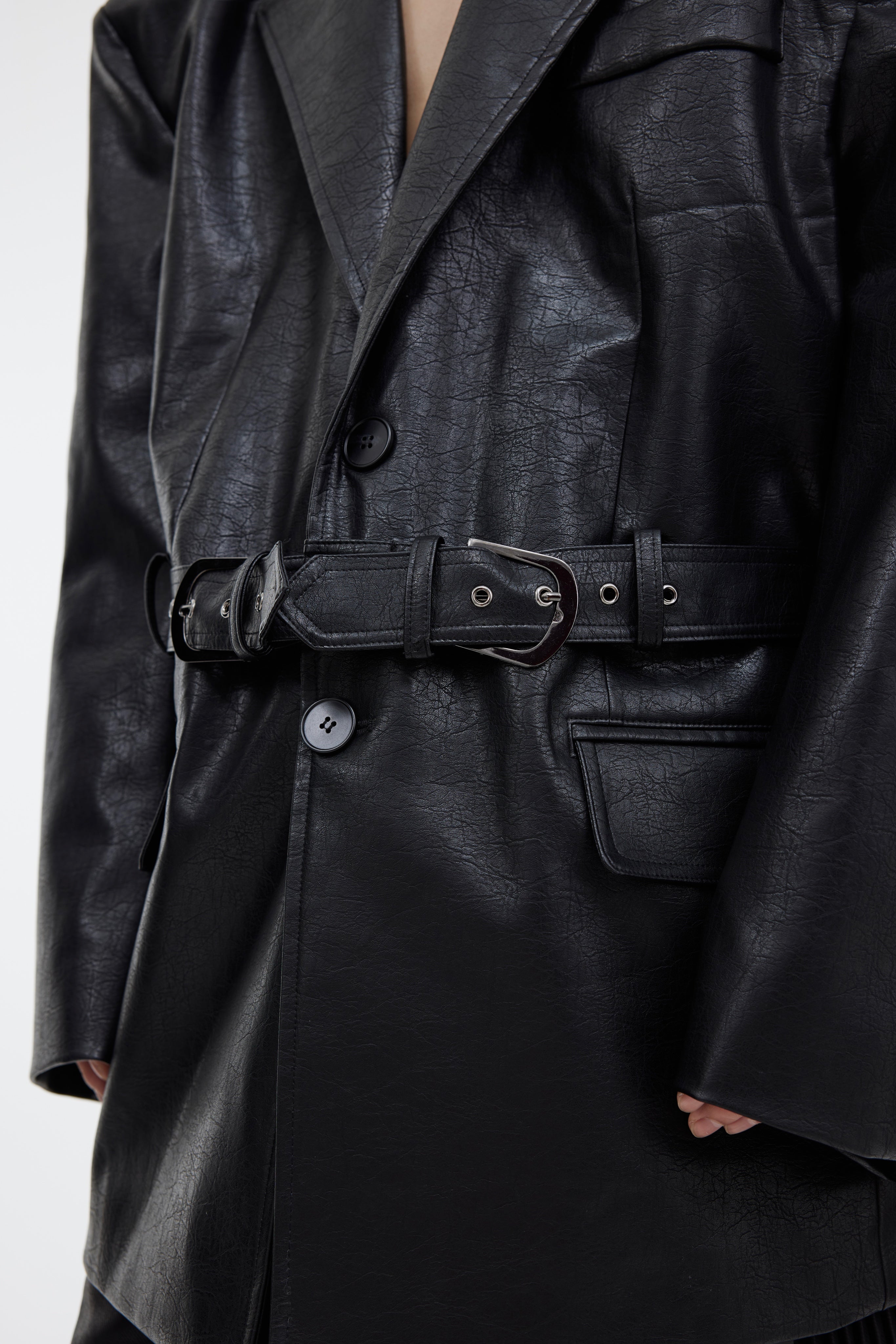 Side profile of adjustable belted leather blazer showcasing its sharp silhouette and waist-cinching design