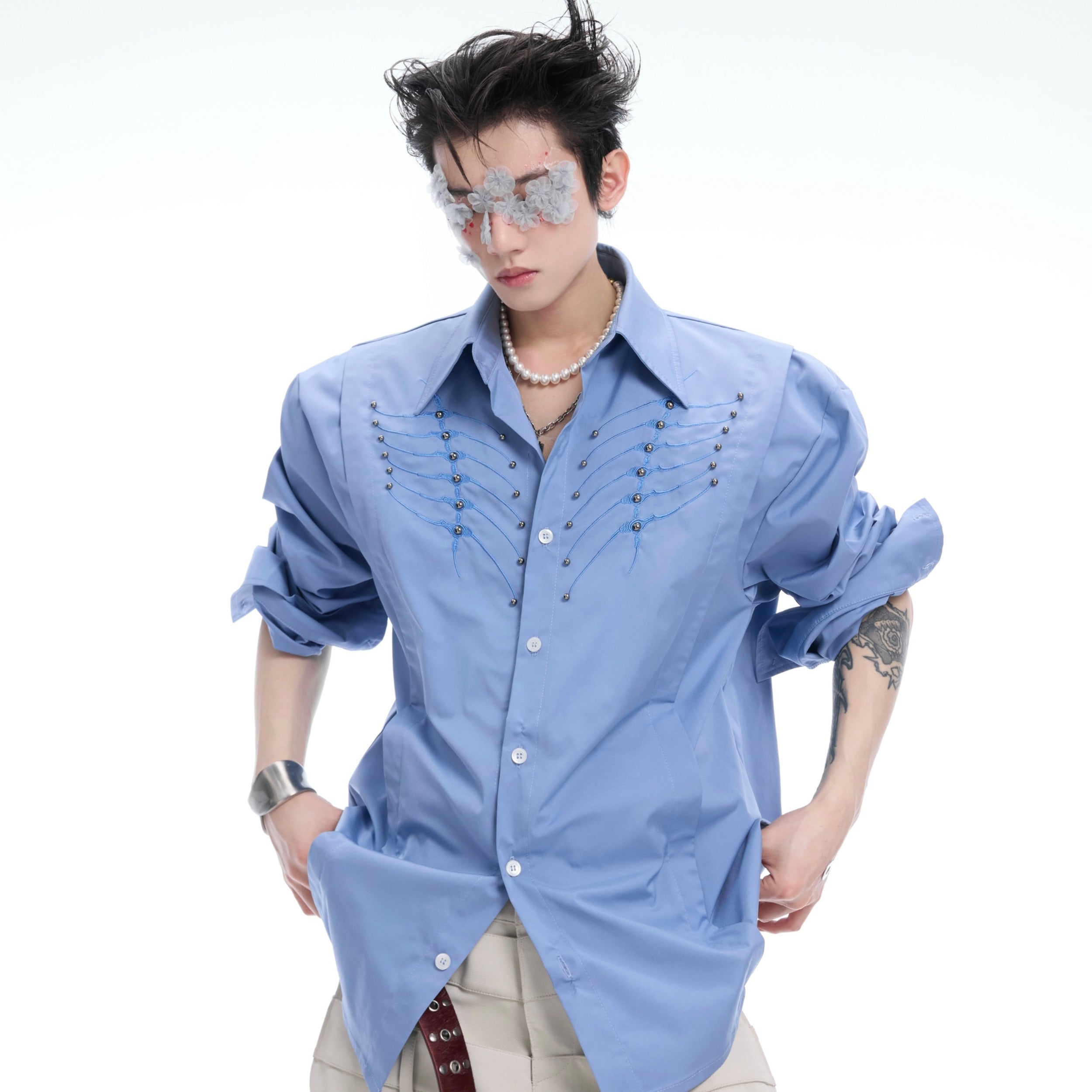 Close-up of deconstructed bone stitch embroidery on black streetwear shirt with oversized fit