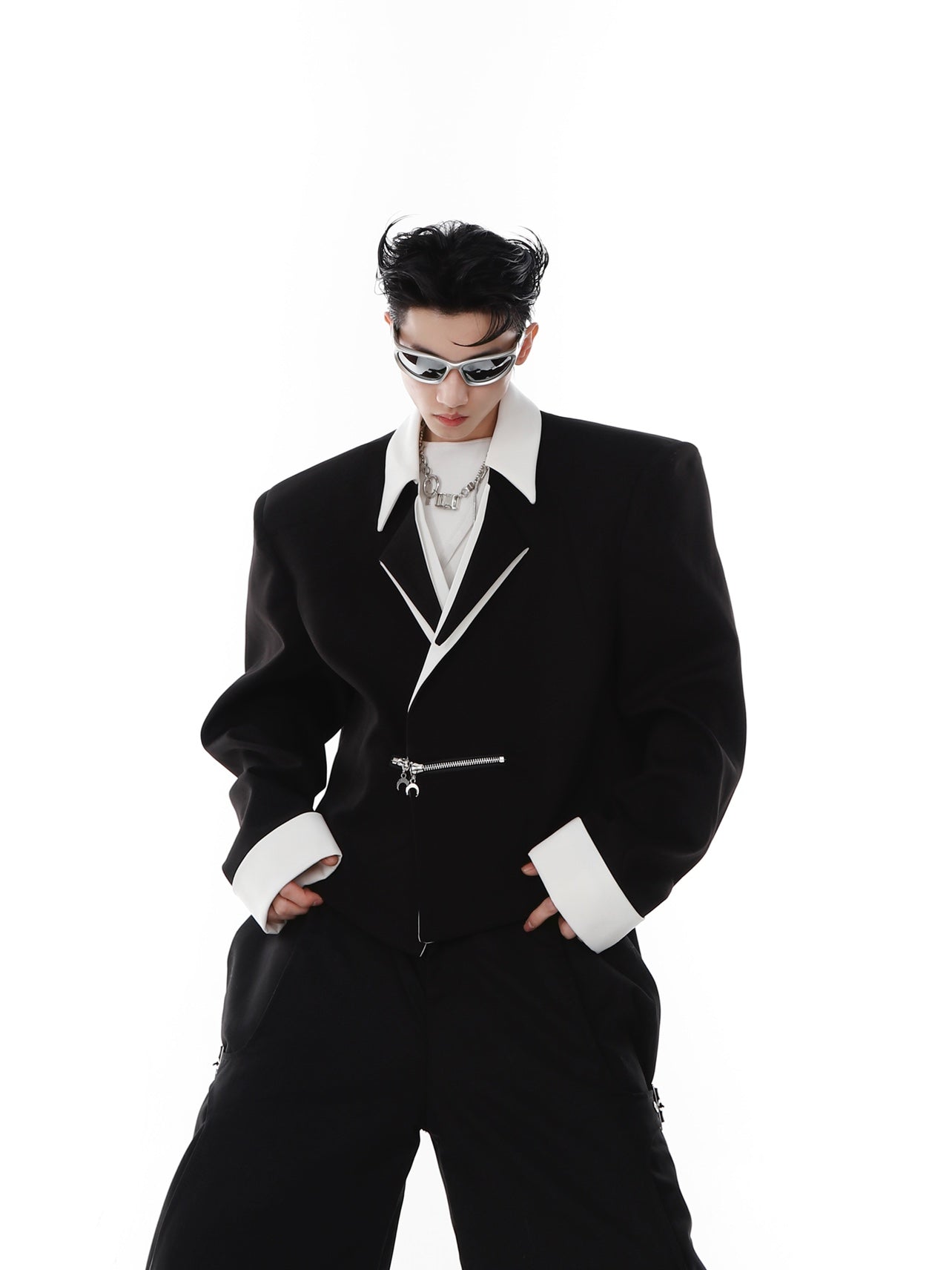 Front view of avant-garde black and white cropped blazer with striking metallic zipper details for edgy streetwear looks