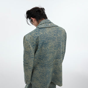 Back view of unique denim blazer jacket showing distressed texture and punk-inspired deconstructed design