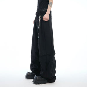 Front view of deconstructed drop-crotch trousers showing unique layered waist design in streetwear style
