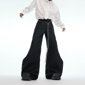 Front view of streetwear deconstructed flared pants with edgy metal chain detailing and micro-rips