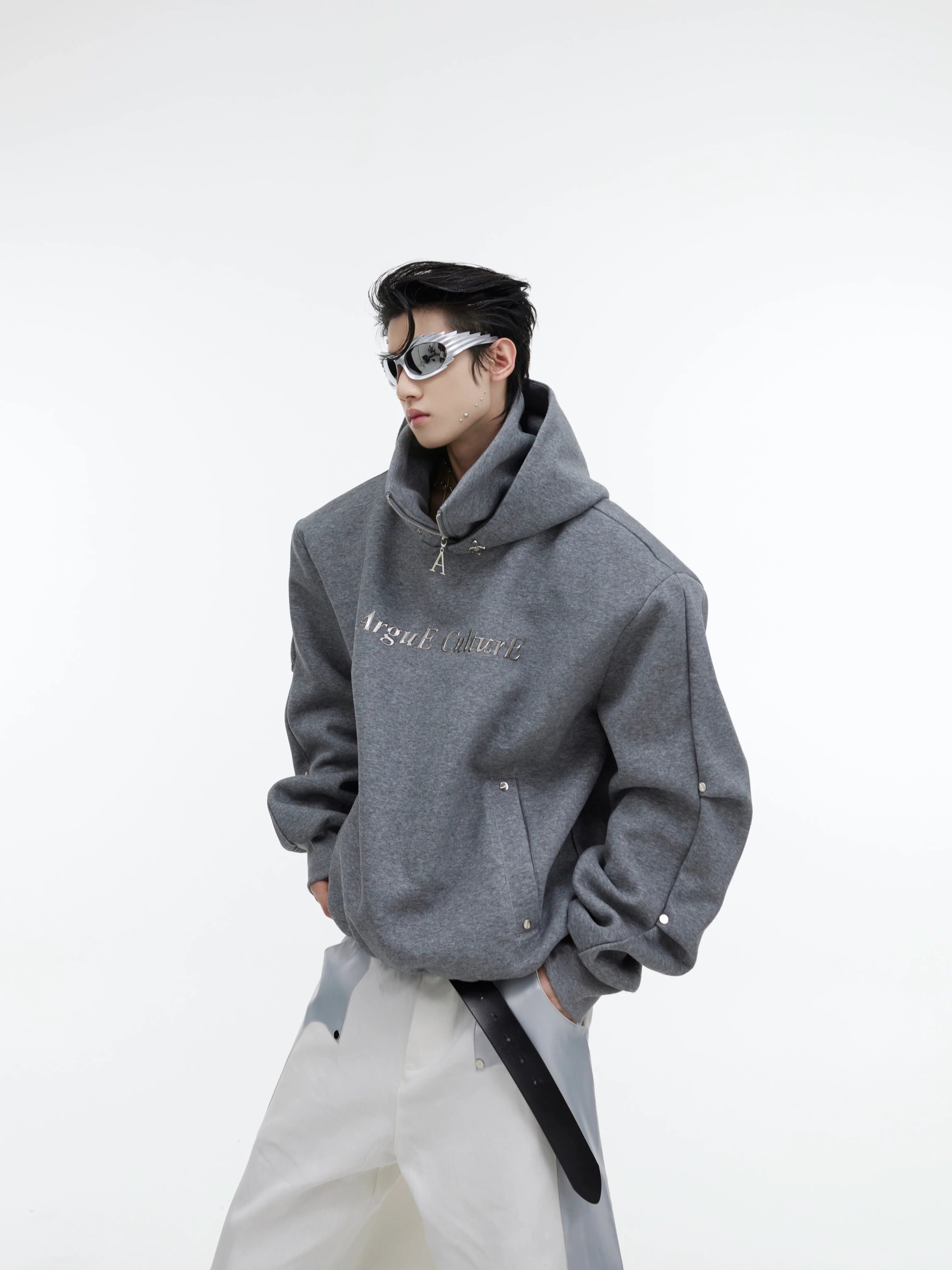 Front view of deconstructed glitter hoodie with high neck and metal buttons, showcasing street-ready style