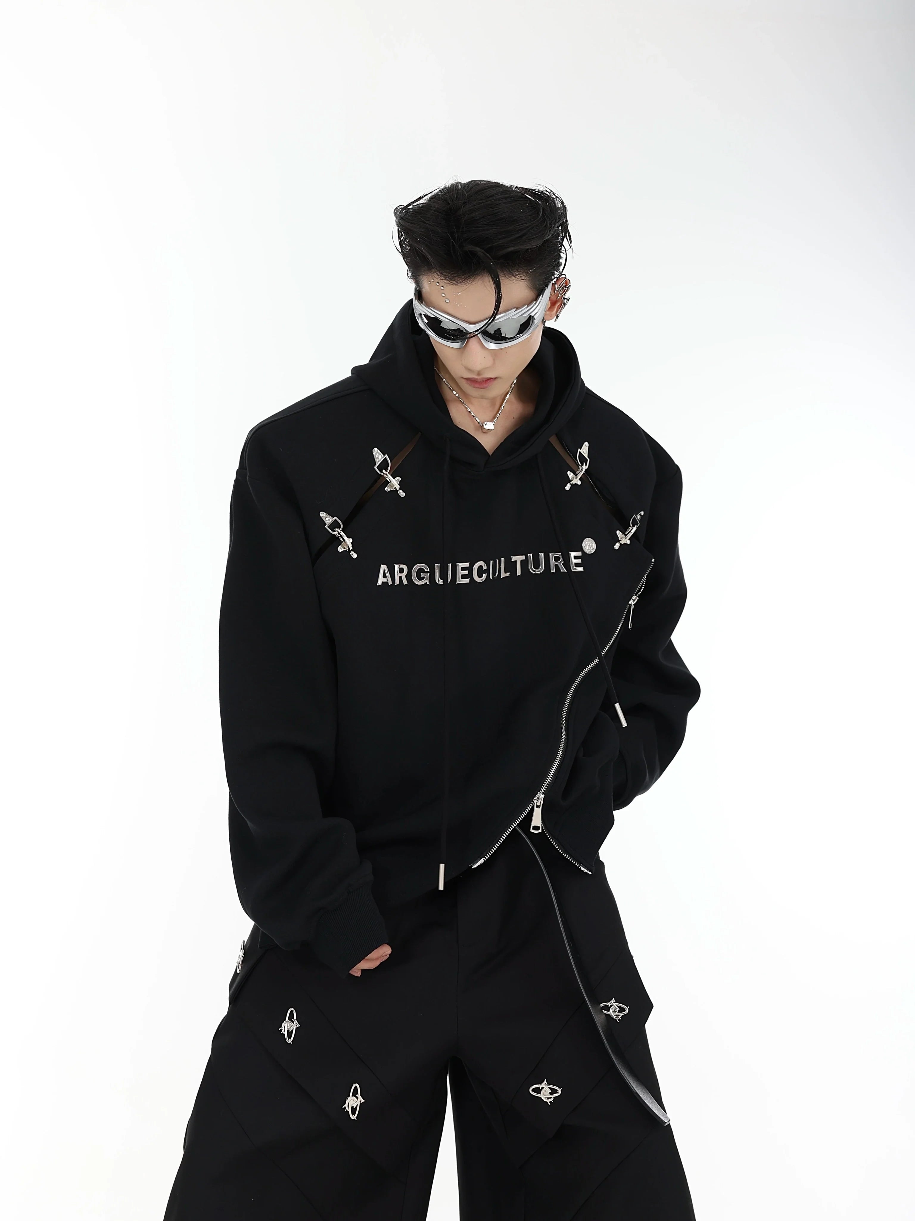 Front view of asymmetrical zip-up hoodie featuring bold metal grommets and diagonal split design for urban streetwear