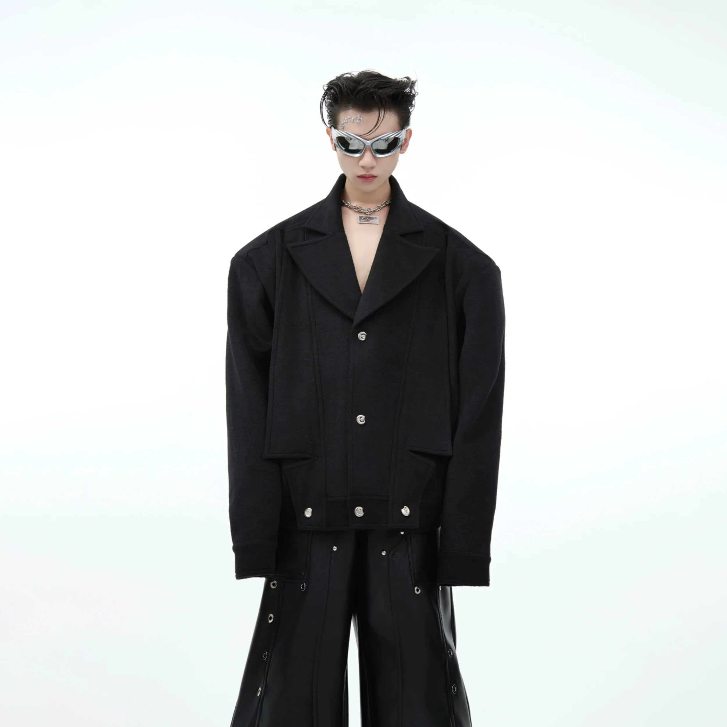 Front view of cropped oversized wool blazer with deconstructed lapel for men, showcasing avant-garde tailoring details