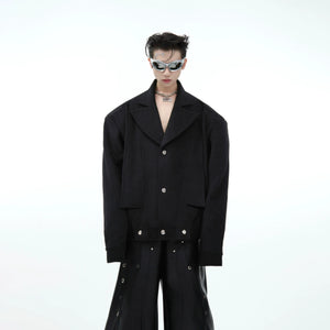 Front view of cropped oversized wool blazer with deconstructed lapel for men, showcasing avant-garde tailoring details