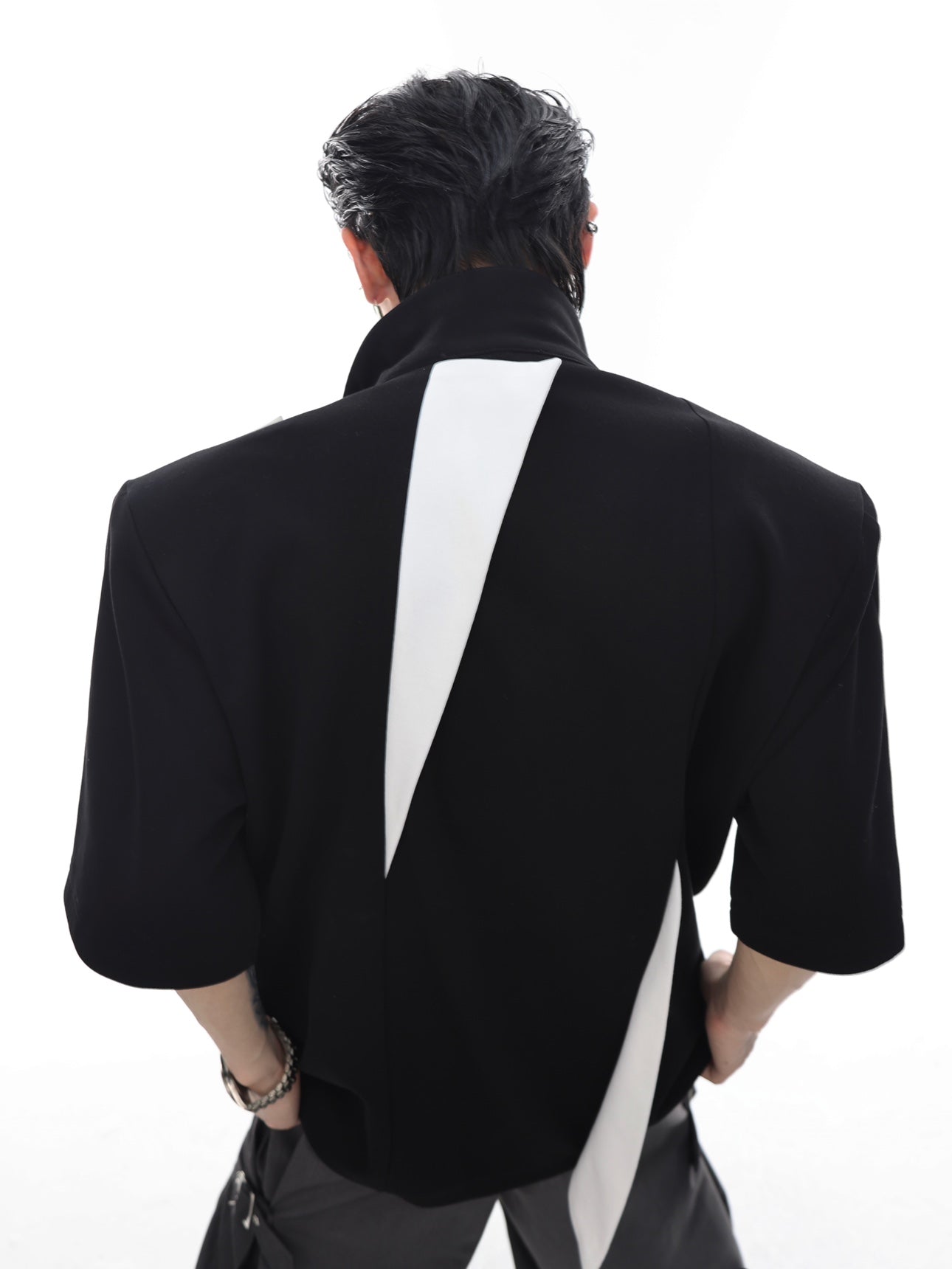 Side view of deconstructed polo shirt showcasing multi-panel construction and heavy-duty streetwear design features