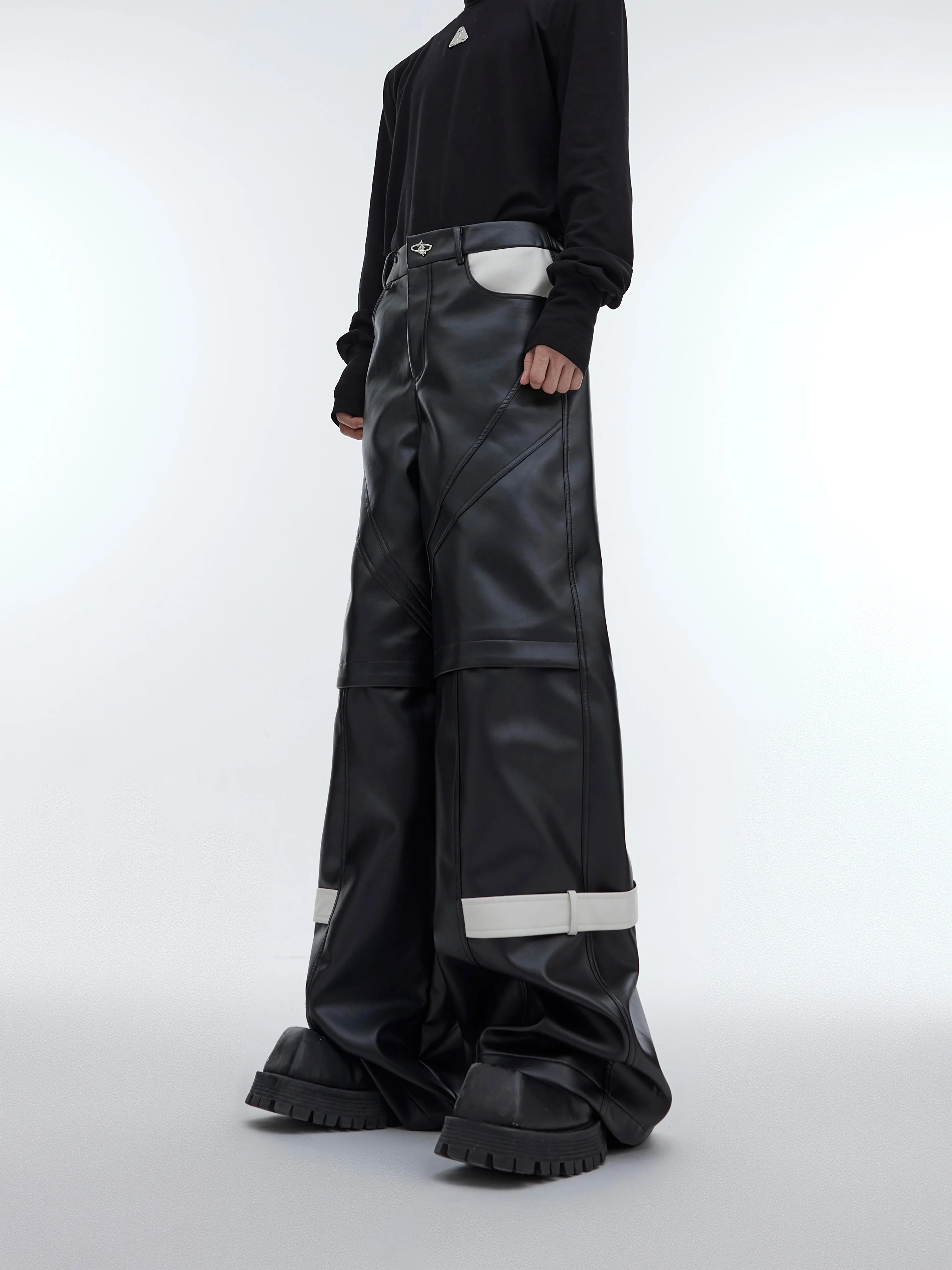 Front view of avant-garde deconstructed leather pants with bold geometric cutouts and belt detailing