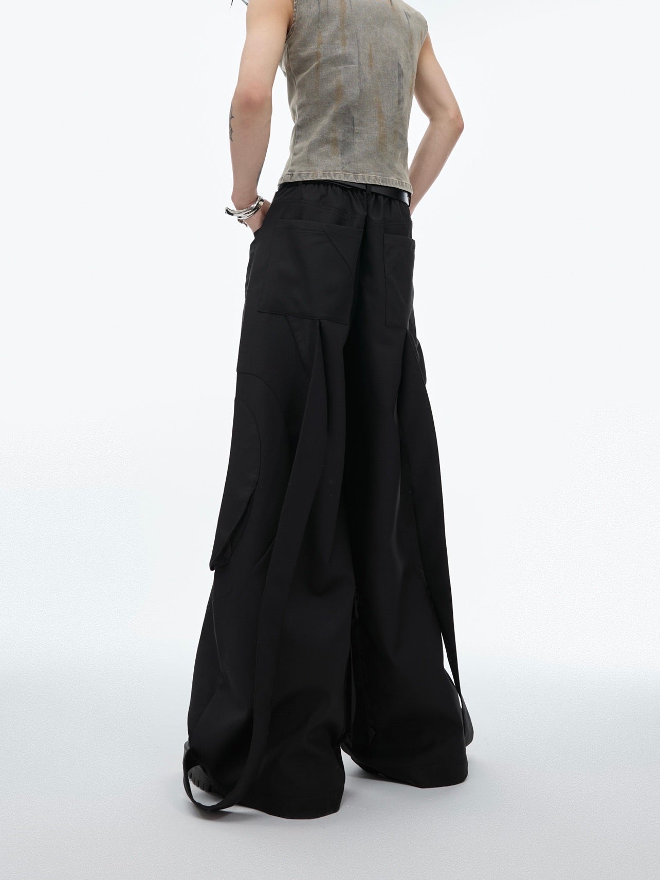 Side angle showing avant-garde deconstructed tailoring and oversized silhouette of these fashion-forward trousers