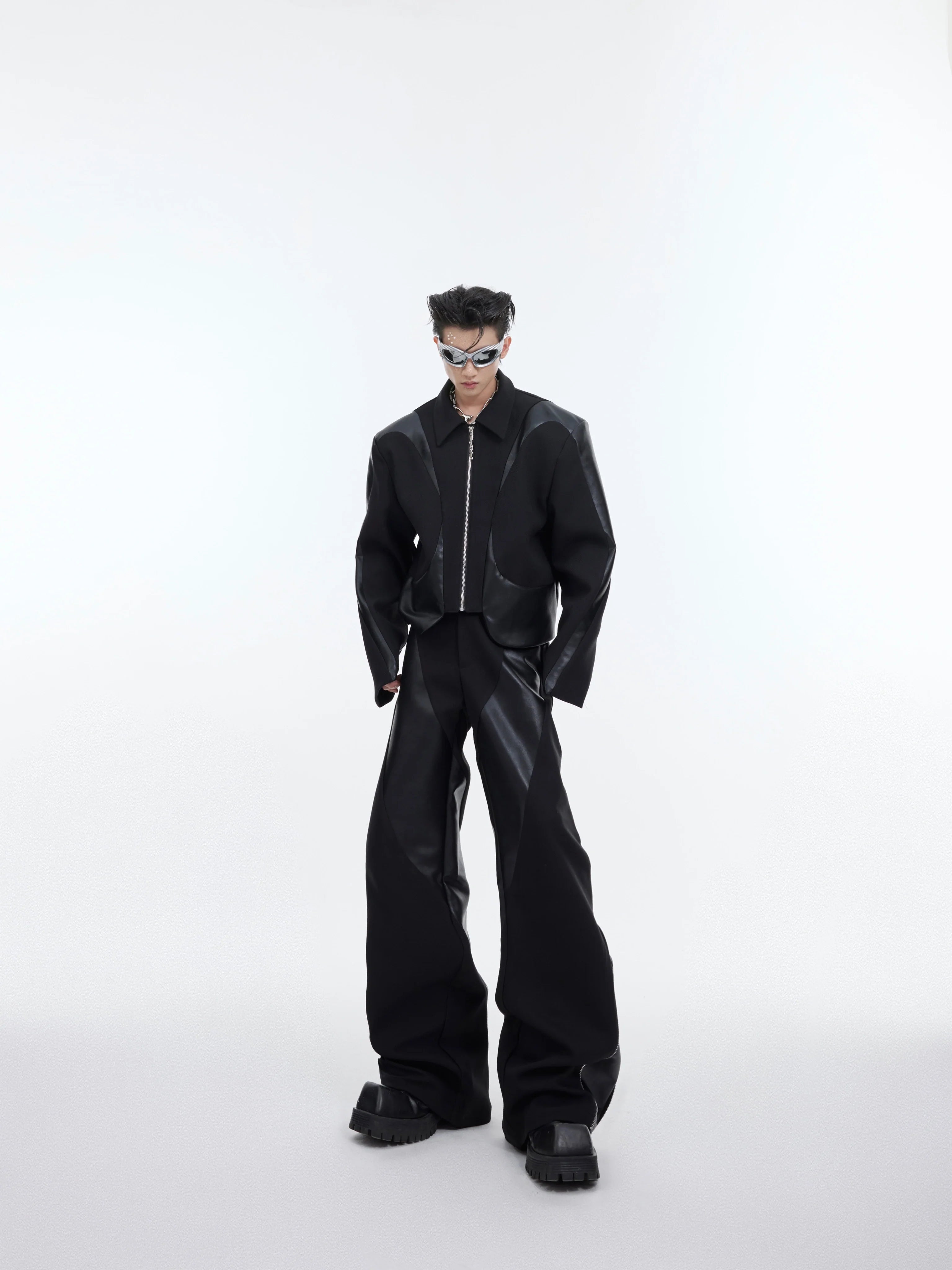 Front view of deconstructed shoulder-pad jacket with leather trim, showing unique patchwork design and urban style