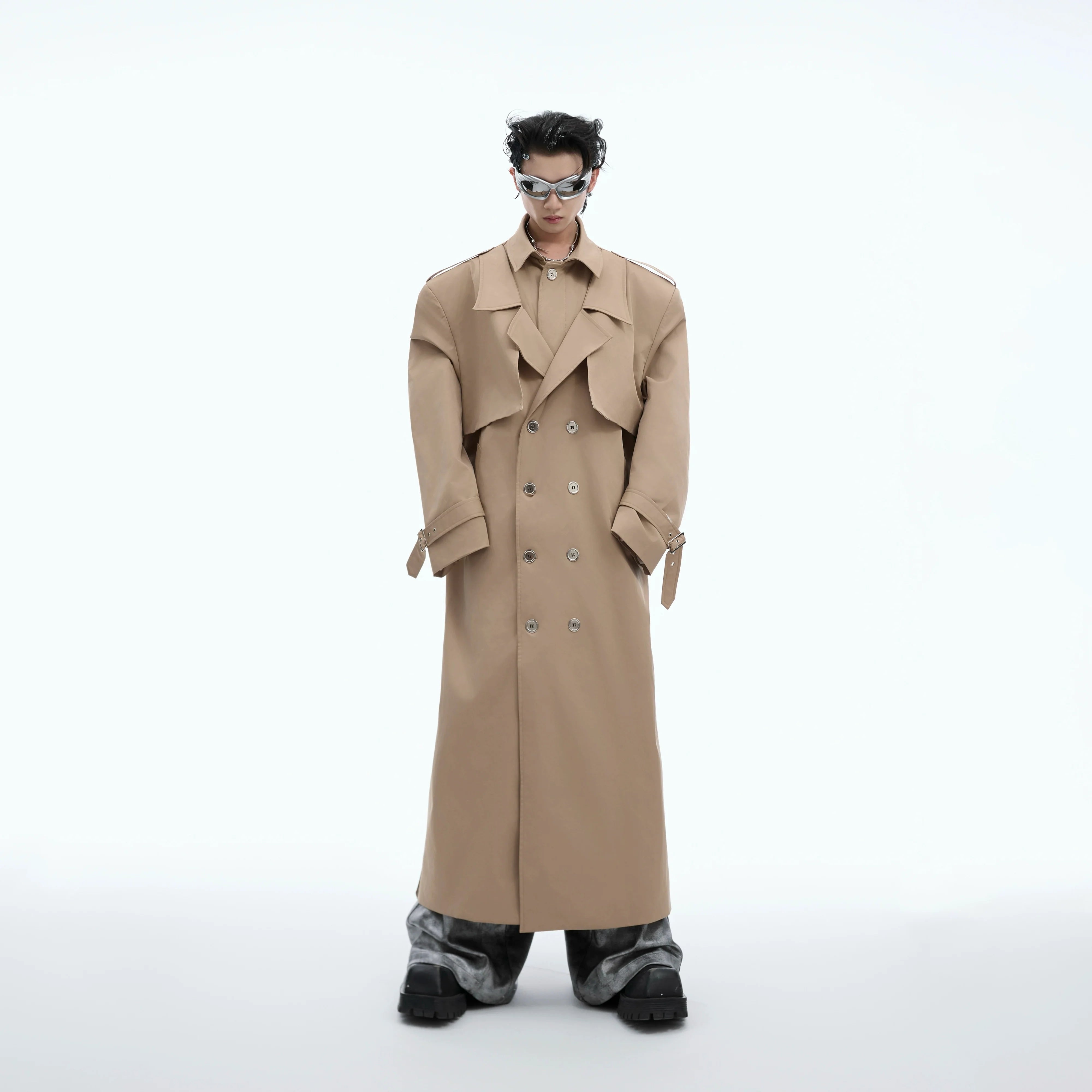 Front view of oversized metallic trench coat with deconstructed shoulder pads, showcasing avant-garde street style