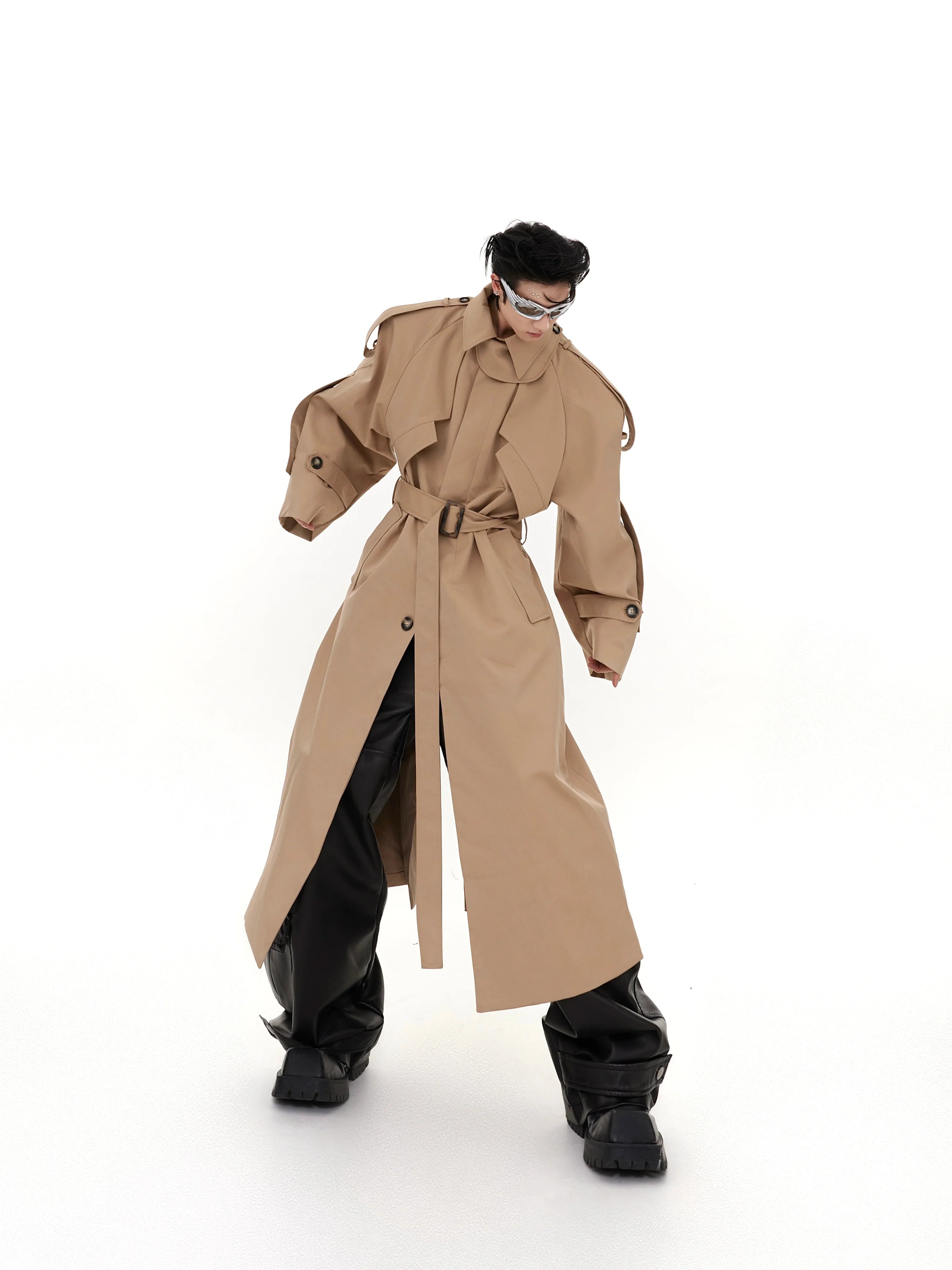 Deconstructed long trench coat with oversized shoulder pads, showcasing avant-garde streetwear style and architectural silhouette