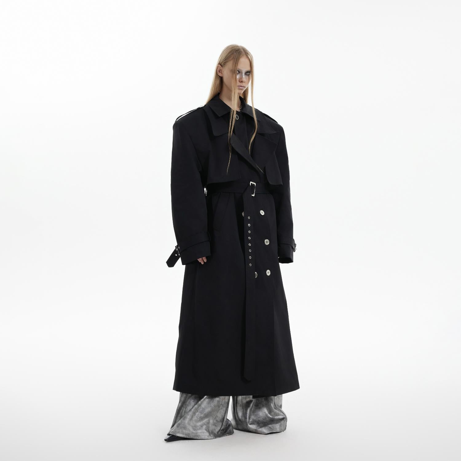 Side profile of long double-breasted trench coat with padded shoulders and luxury fabric drape