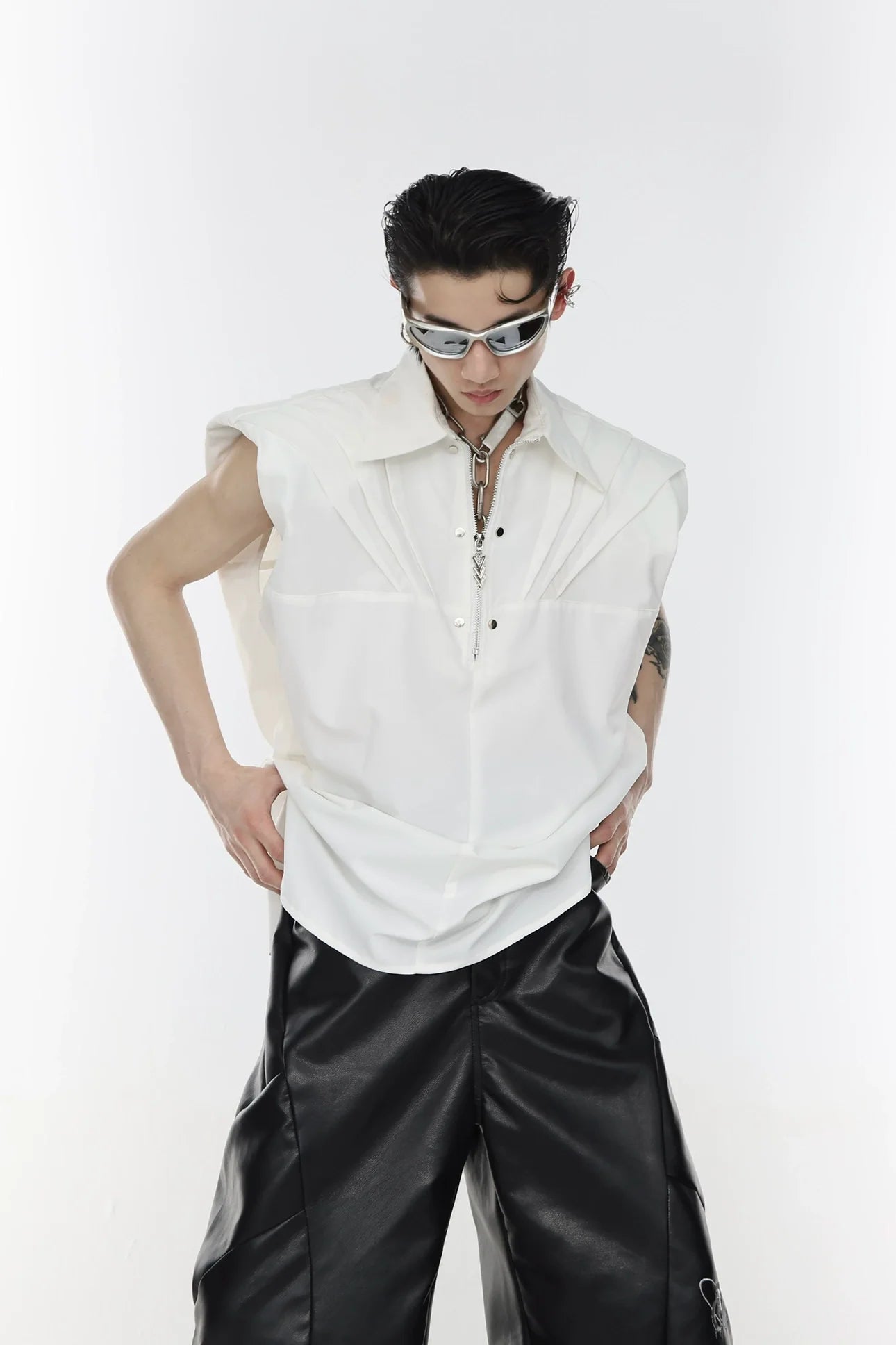 Front view of avant-garde sleeveless shirt featuring striking metal zippers and 3D pleated design for bold streetwear style