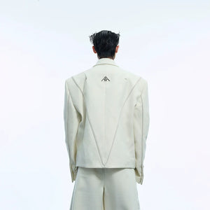 Front view of oversized white blazer with asymmetrical design and metal accents, perfect for streetwear outfits