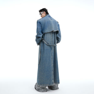 Close-up of color-blocked texture and distressed wash on this avant-garde denim trench coat with modern edge