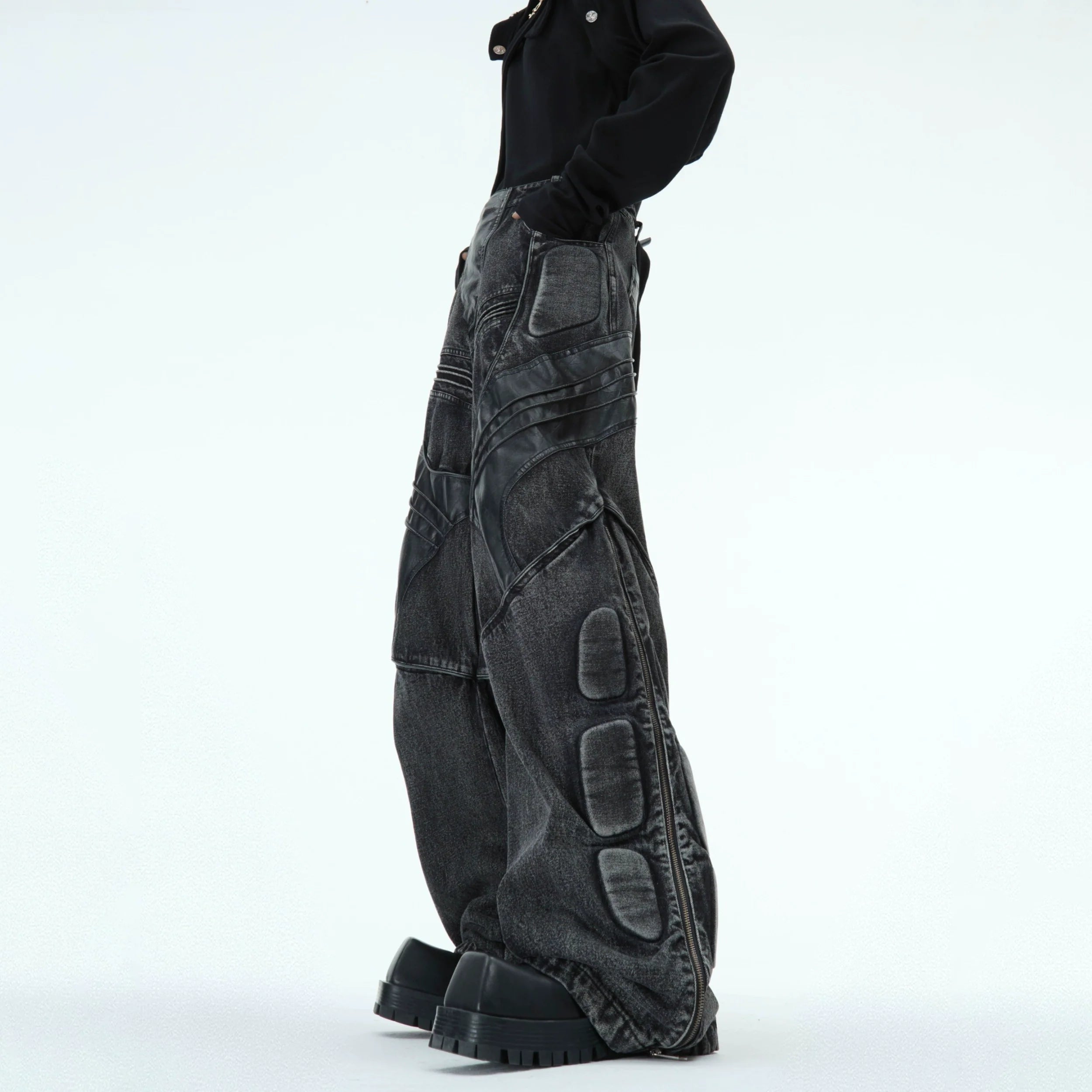 Washed black cyberpunk jeans with distressed details and deconstructed PU leather panels, front view