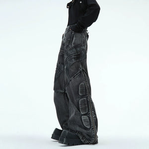 Washed black cyberpunk jeans with distressed details and deconstructed PU leather panels, front view