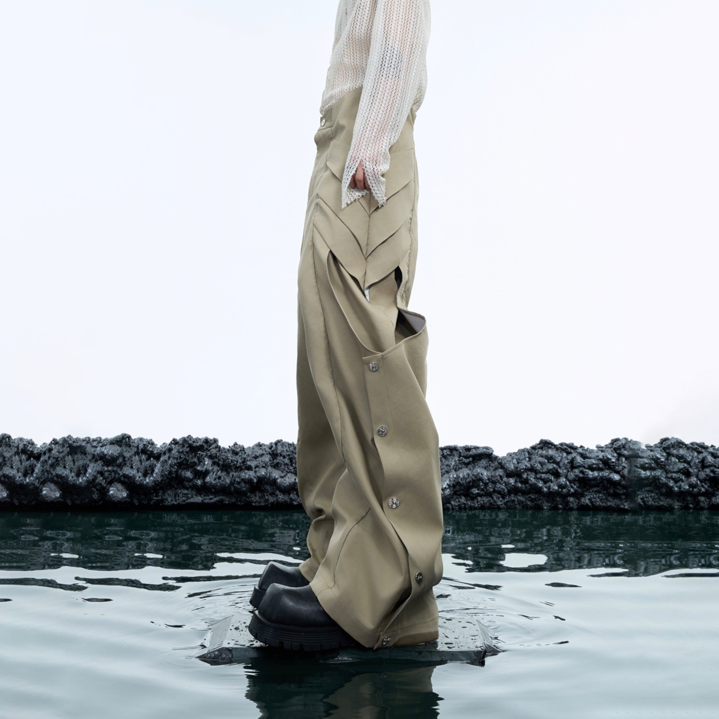 Front view of distressed cargo pants with metal snaps and pleats, showcasing the urban streetwear design and loose fit