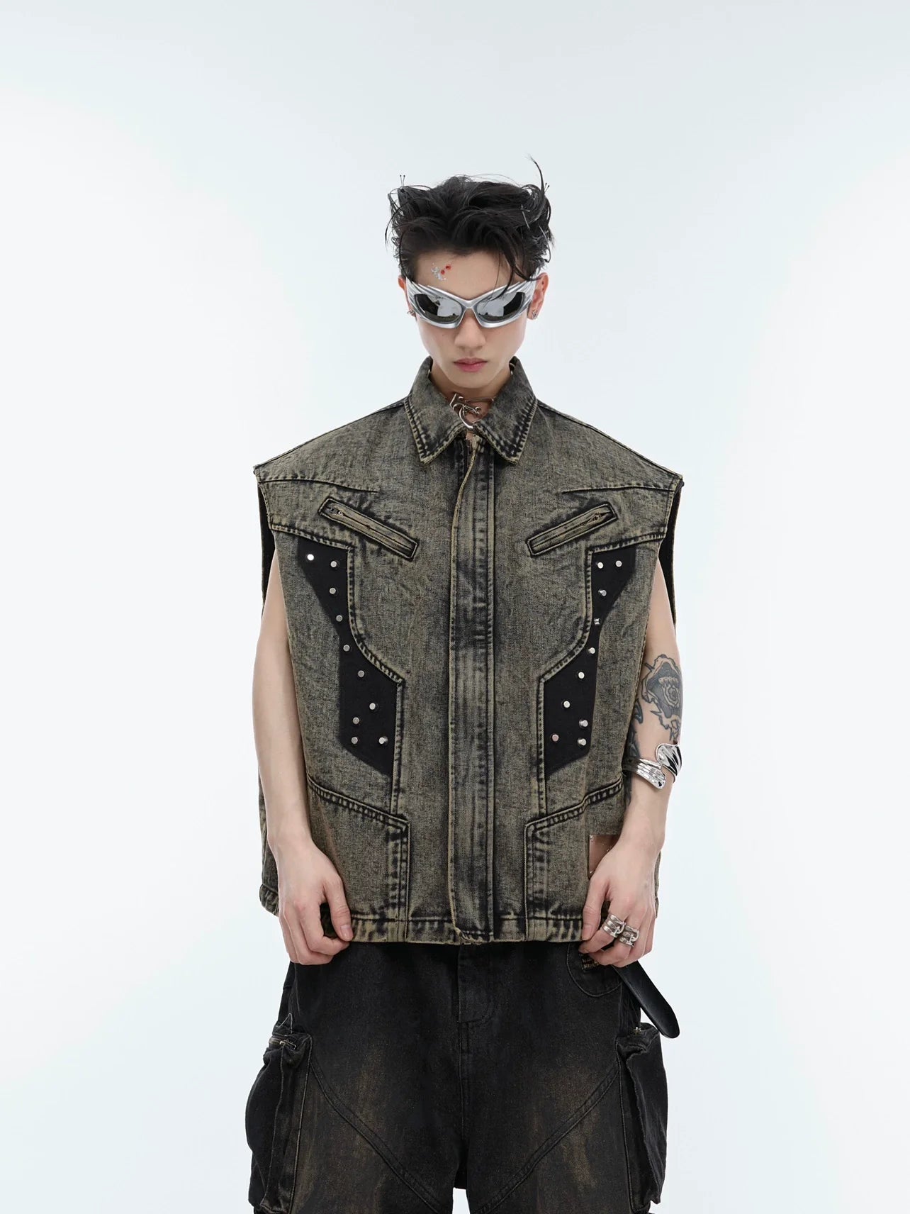 Front view of distressed denim vest with deconstructed metal studs, showcasing asymmetrical streetwear design