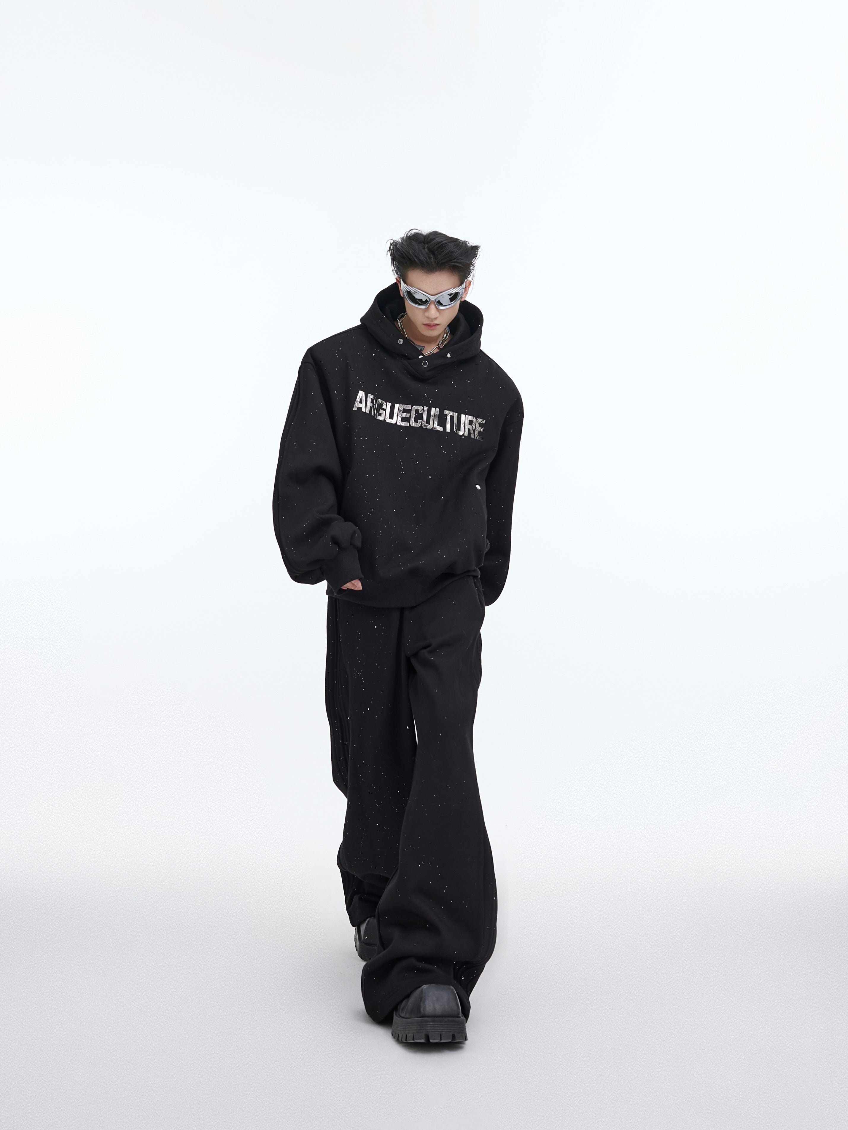 Distressed wide-leg pants paired with textured tracksuit hoodie, showing street-ready athletic wear with bold seams