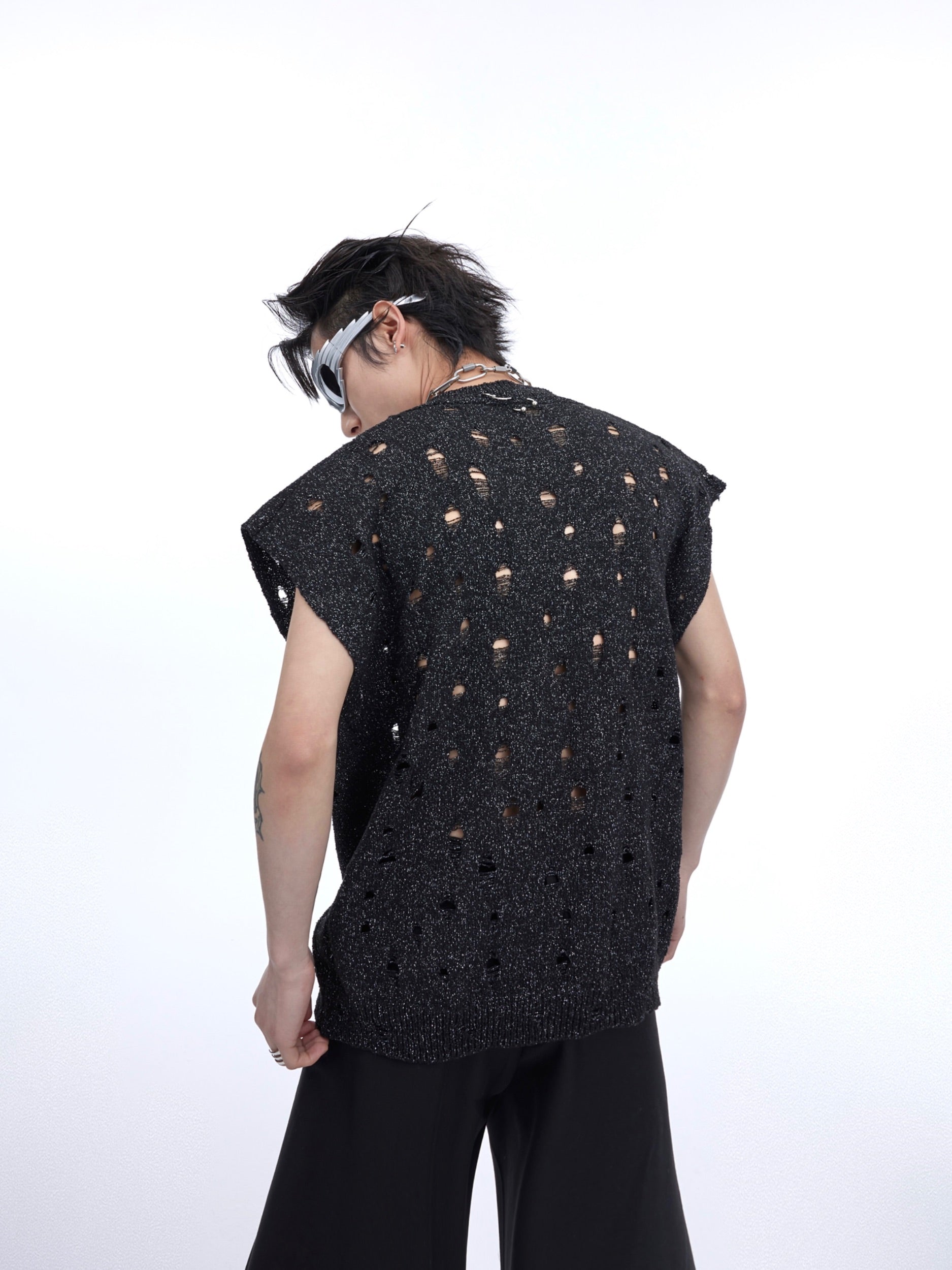 Close-up of the irregular torn hem on this metallic knit tank top with raw edge streetwear aesthetic