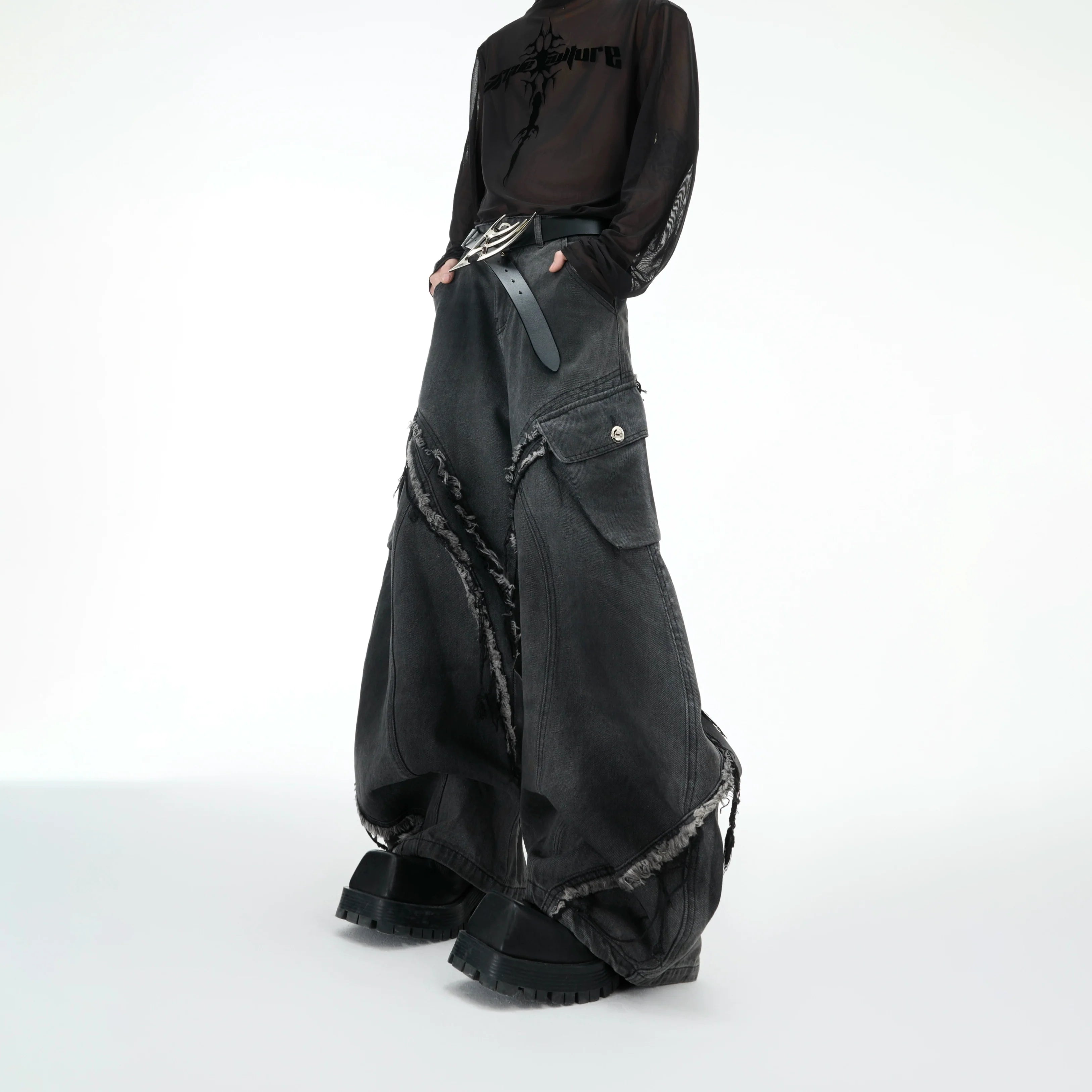 Distressed vintage wide-leg jeans with raw hem detailing, showing relaxed fit and deconstructed fringe design