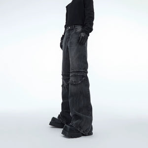 Distressed grey straight-leg jeans with raw hem and water ripple fringe detailing, perfect for edgy streetwear looks
