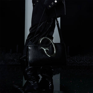 Unique asymmetrical crossbody bag with metal chain accents for a bold fashion statement