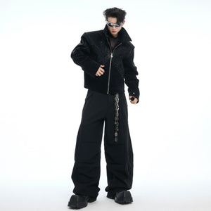 Detailed close-up of custom metal logo zipper on croc-textured oversized bomber jacket