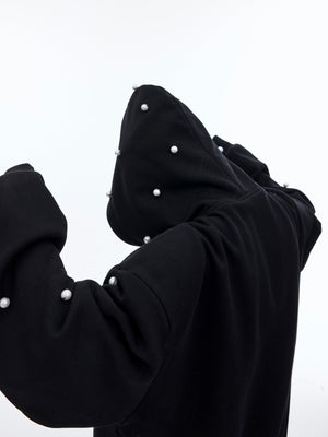Close-up detail of luxury pearl embellishments on warm fleece-lined oversized hoodie