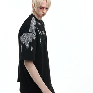 Close-up of asymmetric hem on gold sequin t-shirt showing avant-garde streetwear design