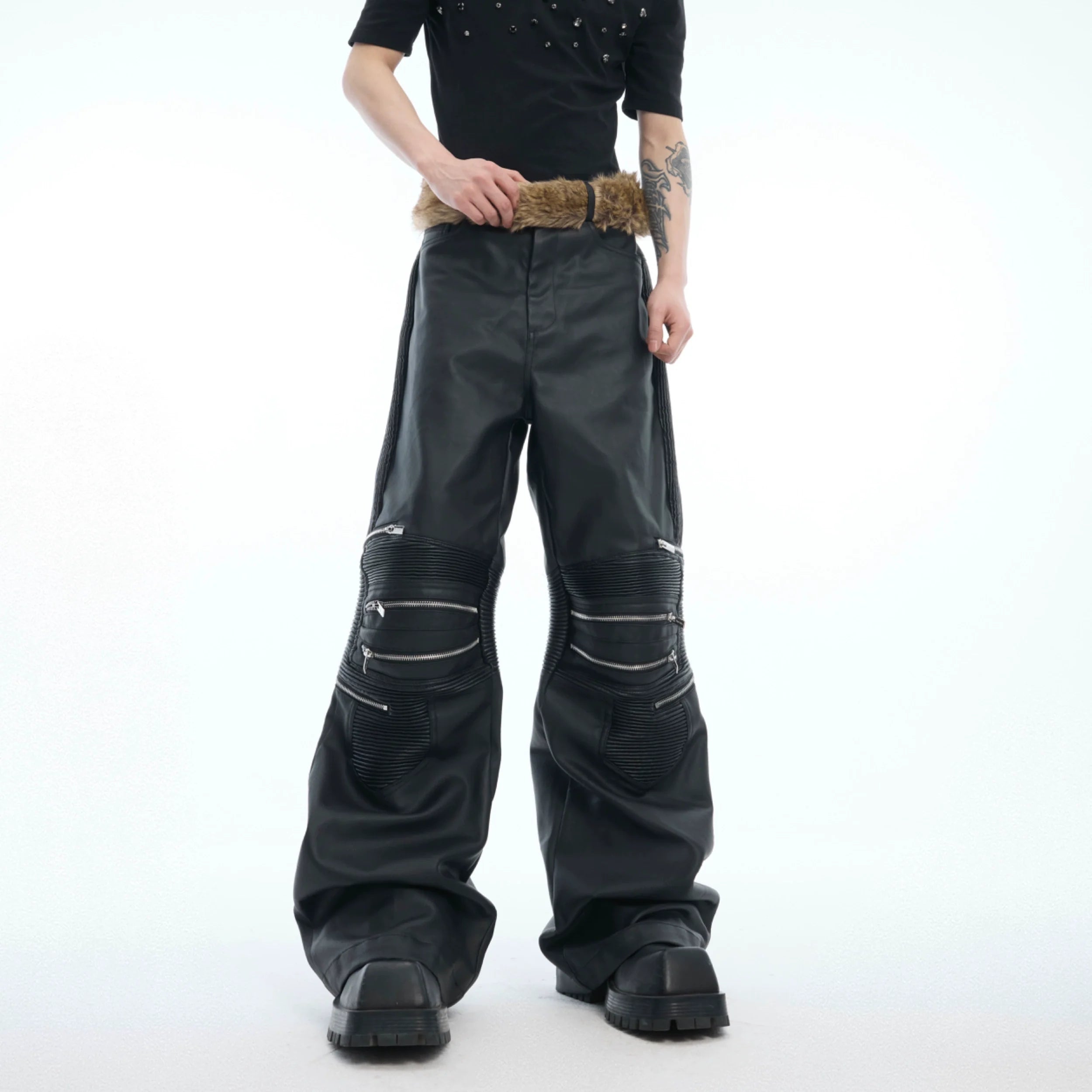 Deconstructed high-waist leather pants with metal zipper detailing, showcasing streetwear punk style