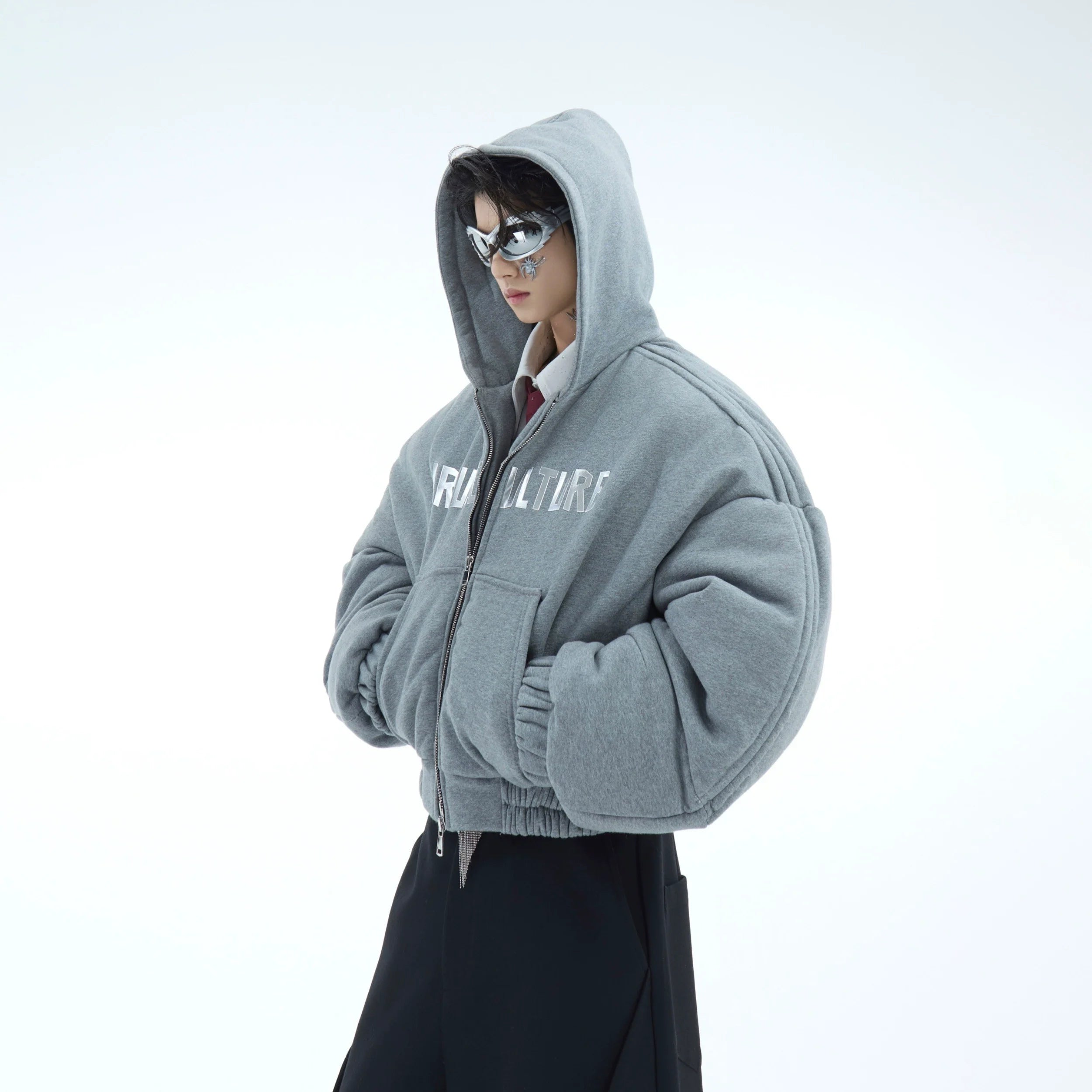 Front view of oversized hooded puffer jacket with bold 3D metal print details for streetwear fashion