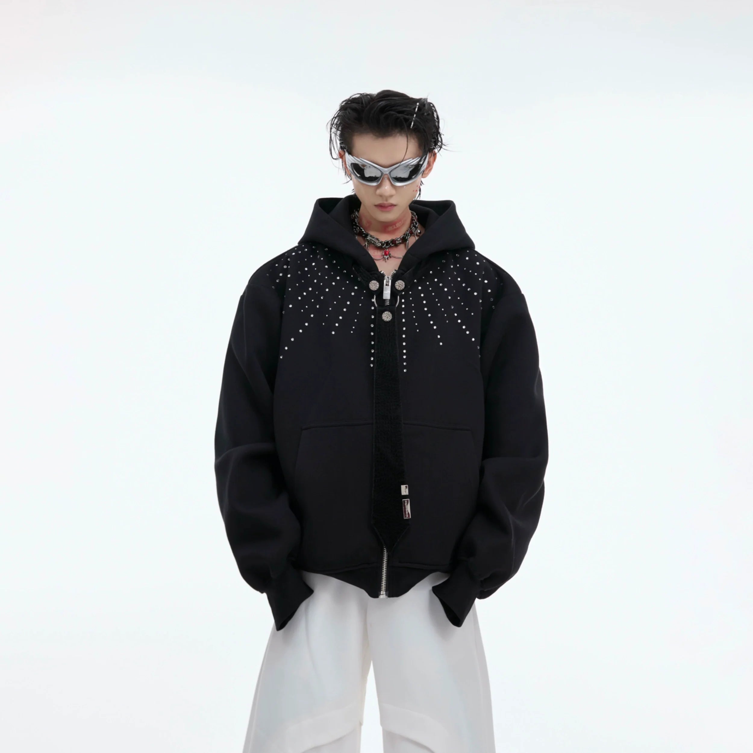 Oversized zip-up hoodie with detachable glitter tie, showcasing avant-garde streetwear design with diamond patches