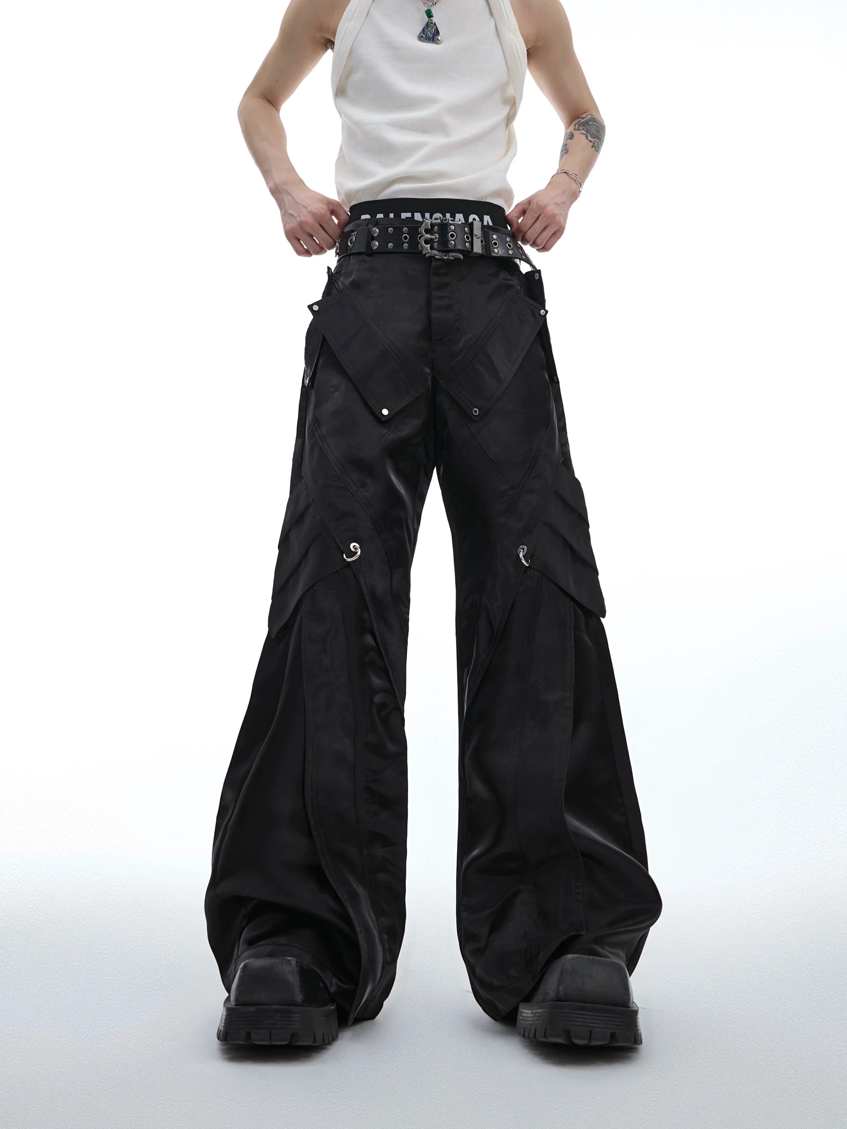 Futuristic liquid-leather pants featuring metallic buckles and flared fit, showcasing avant-garde streetwear design