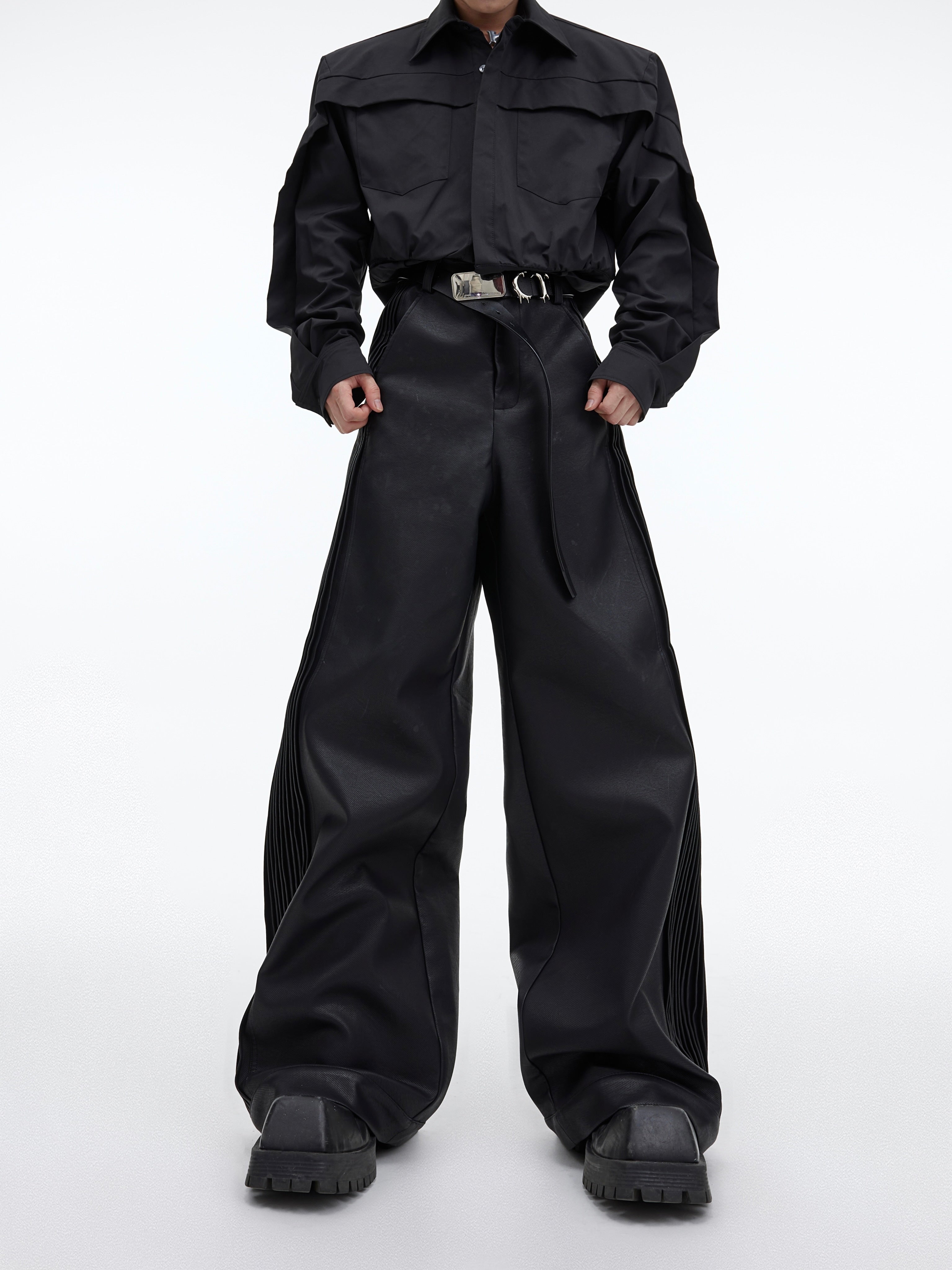 Front view of straight-leg leather pants showcasing signature side pleat detailing and matte PU finish