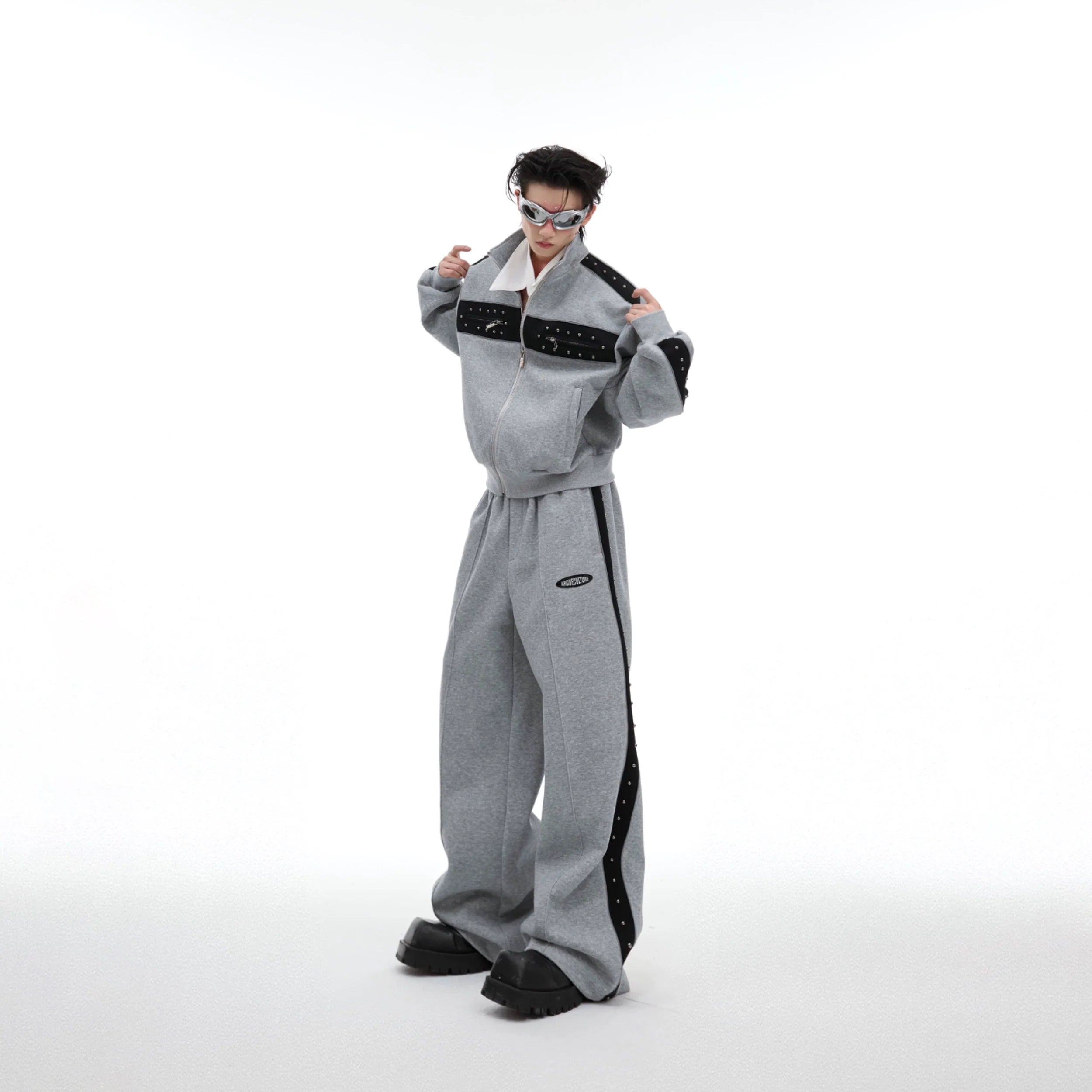 Front view of drop-shoulder cropped hoodie with metal stud details, paired with matching joggers for urban streetwear look