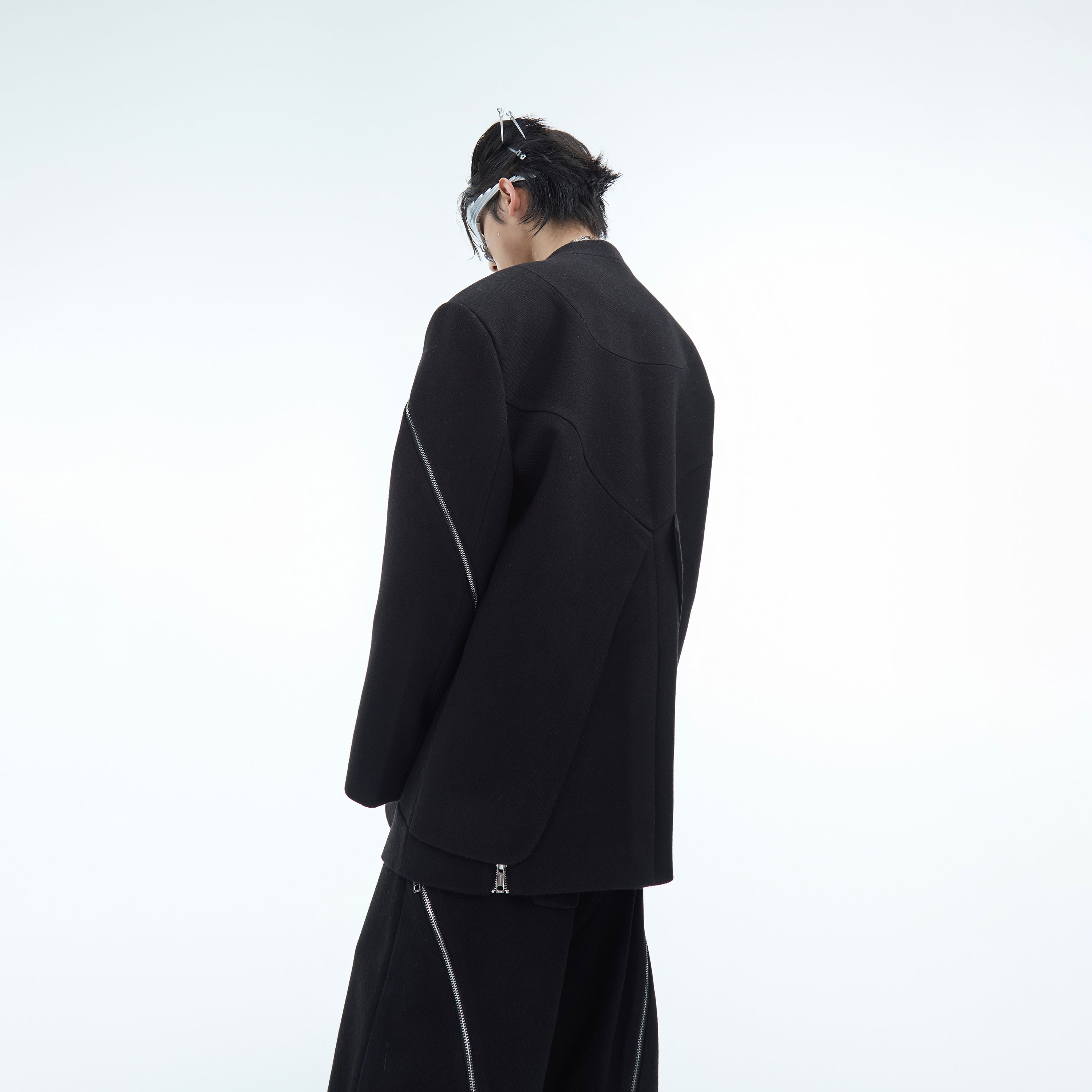 Side profile of structured yet relaxed fit metal-zipper blazer with urban streetwear aesthetic