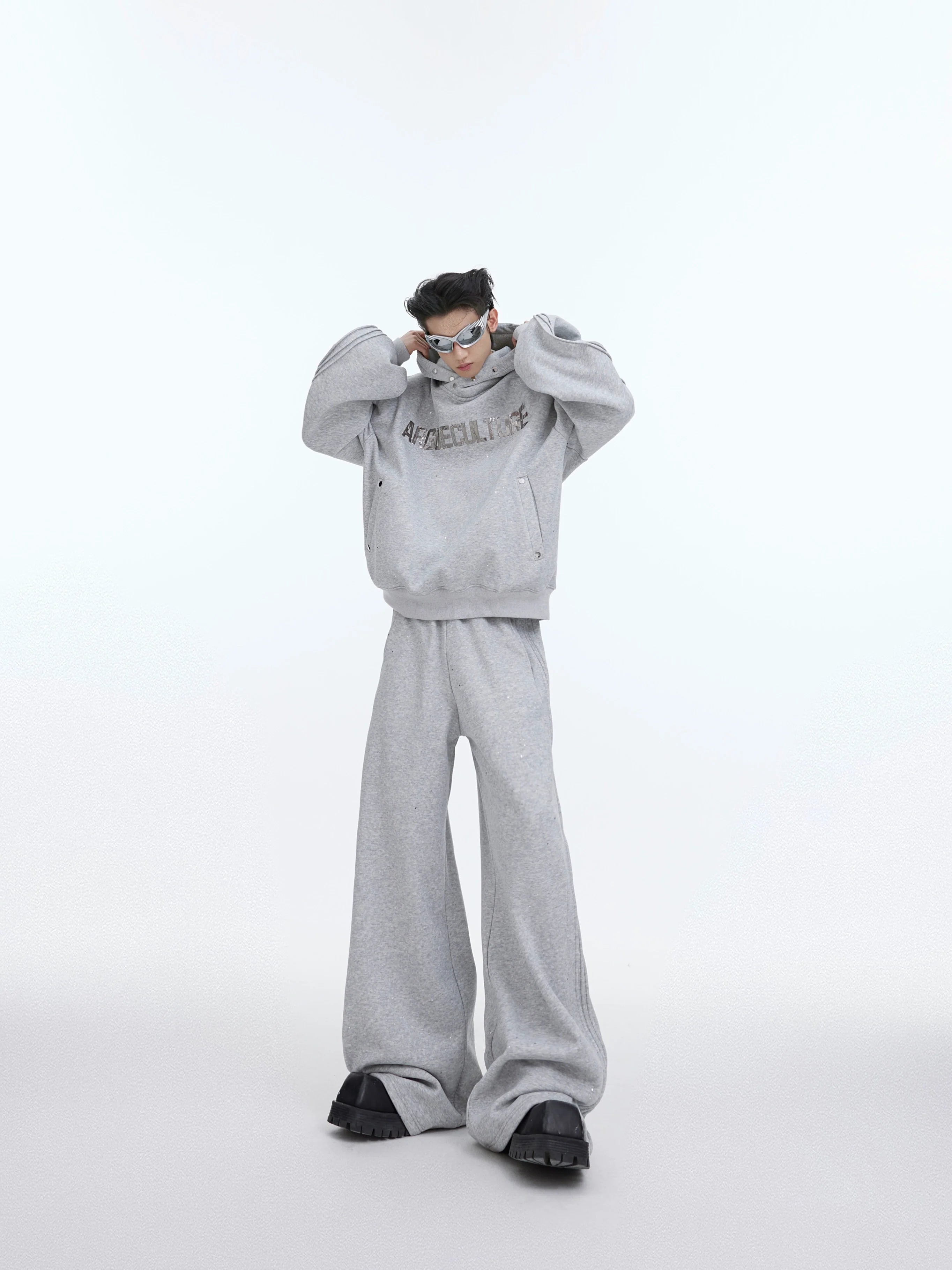 Oversized hoodie with fleece lining and structured shoulders, featuring distressed wide-leg pants for urban streetwear style
