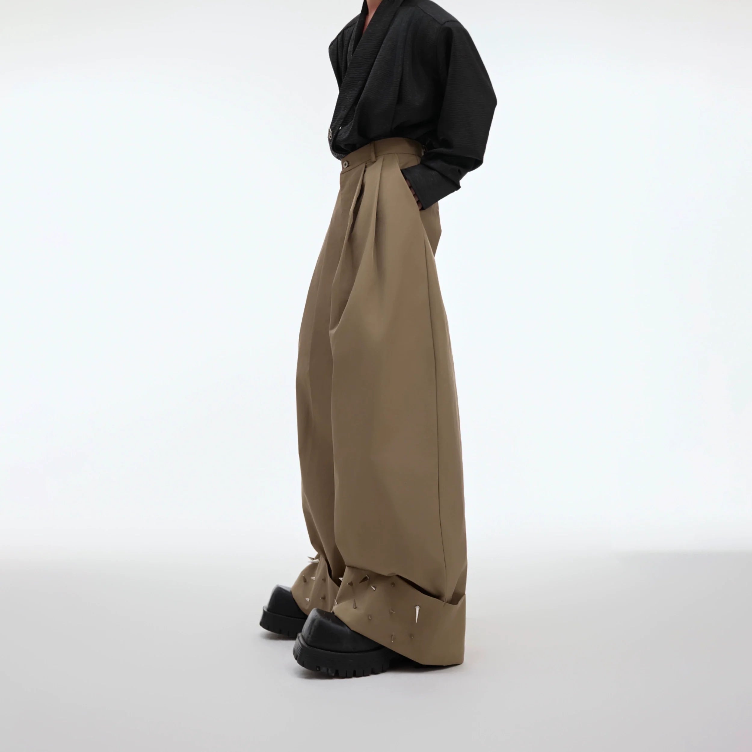 Front view of oversized metal-stud trousers with futuristic 3D deconstructed design for avant-garde streetwear