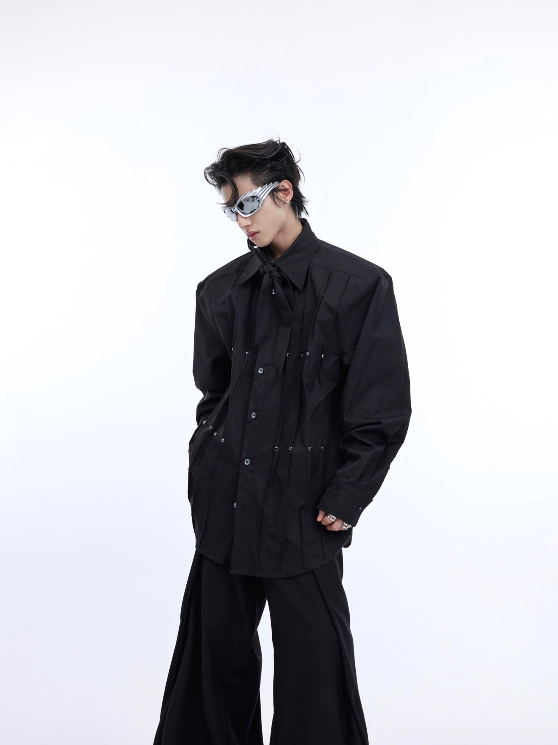 Side angle showing asymmetric design and dramatic pleating on this gender-neutral oversized white shirt