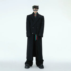 Front view of oversized deconstructed wool coat with dramatic split hem, showcasing the streetwear-inspired design