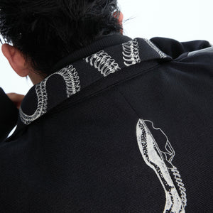 Detail shot of metal zipper and raw edge construction on deconstructed snake print cropped jacket