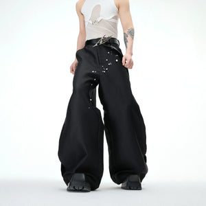 Front view of pearl-embellished waxed wide-leg pants showing streetwear style with gemstone accents