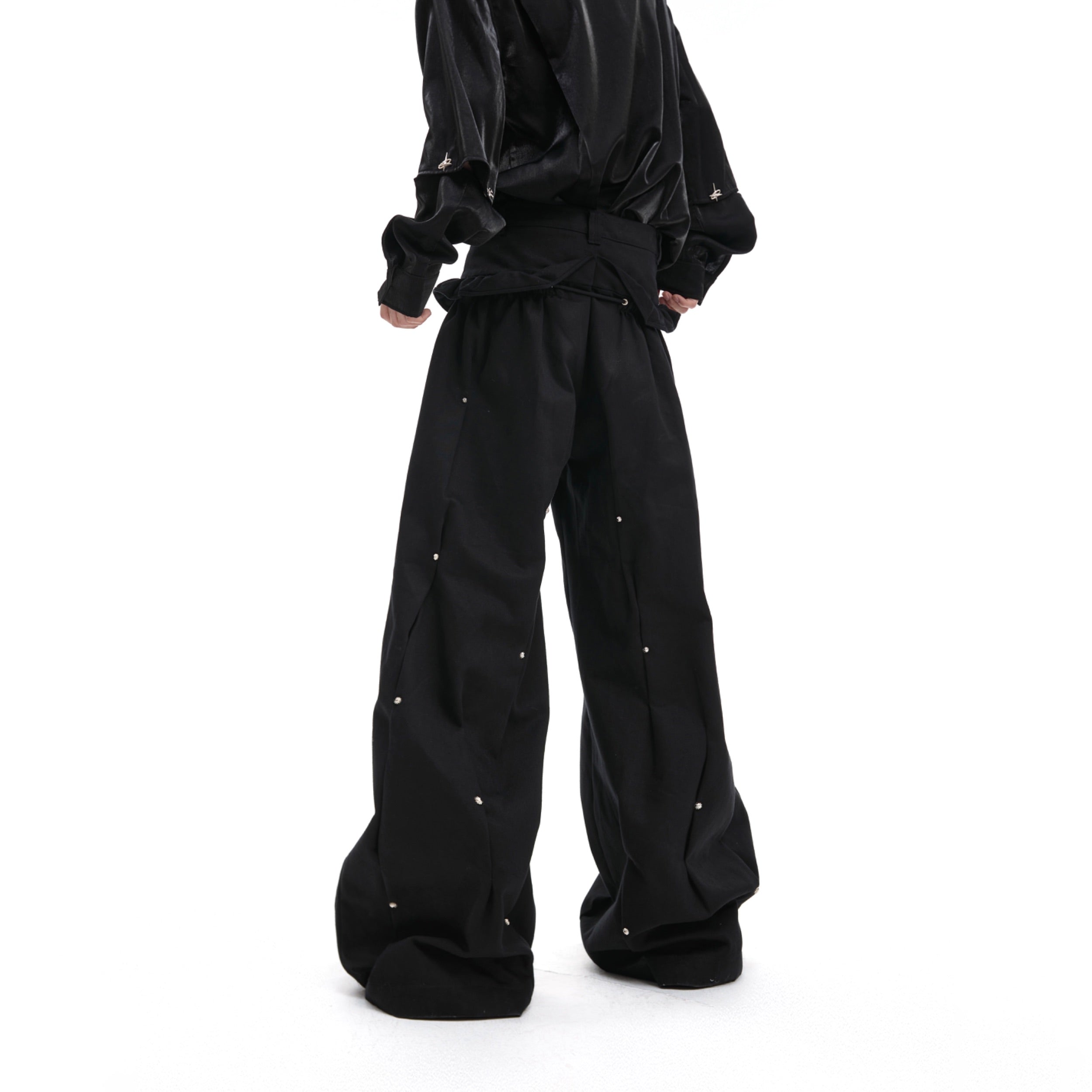 Side angle of distressed pleated cargo pants highlighting the deconstructed design and streetwear aesthetic