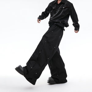 Back view of stacked loose fit pleated pants showing the unique deconstructed tailoring and street style