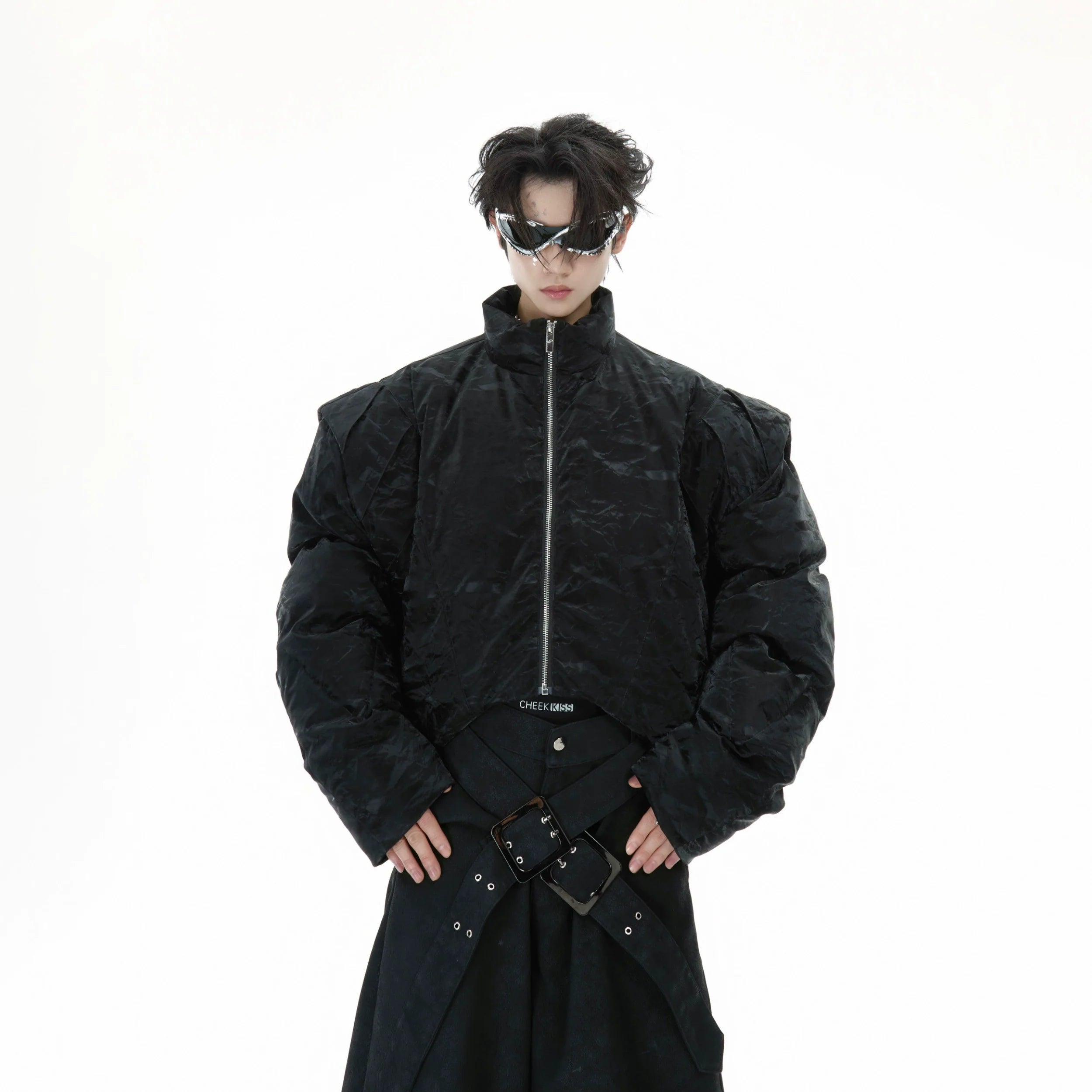 Deconstructed cropped puffer jacket with glossy textured PU-cotton blend fabric, featuring industrial chic design