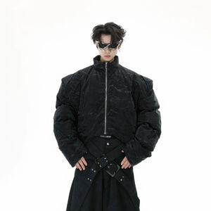 Deconstructed cropped puffer jacket with glossy textured PU-cotton blend fabric, featuring industrial chic design